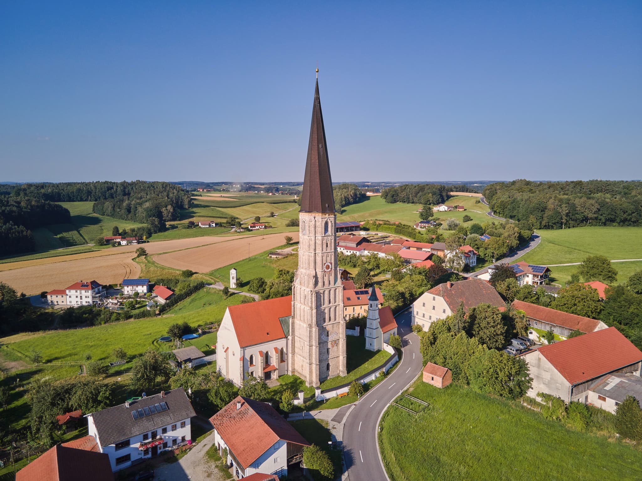 Luftaufnahme von Schildthurn in Zeilarn, Landkreis Rottal-Inn, Niederbayern, Deutschland. Zeigt die Kirche umgeben von Feldern, Wäldern und ländlichen Gebäuden.