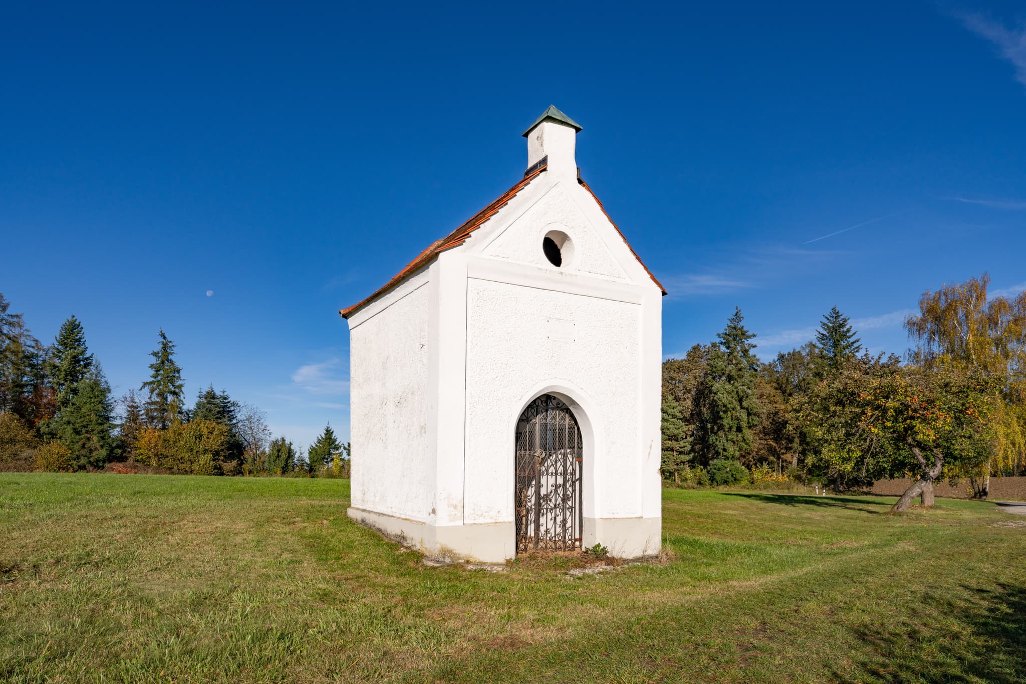 Kleine Kreuzhäusl Kapelle bei Wurmannsquick, Landkreis Rottal-Inn. In Niederbayern, Deutschland, umgeben von Wiesen und Bäumen im Holzland.