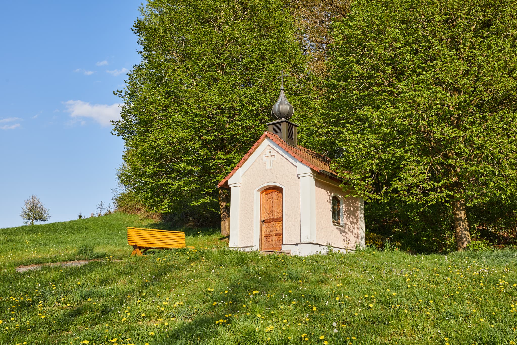 Hickerstall Kapelle in Wurmannsquick, Rottal-Inn, Niederbayern. Eine kleine Kapelle auf einer grünen Anhöhe, umgeben von Wiesen und Bäumen im Holzland.