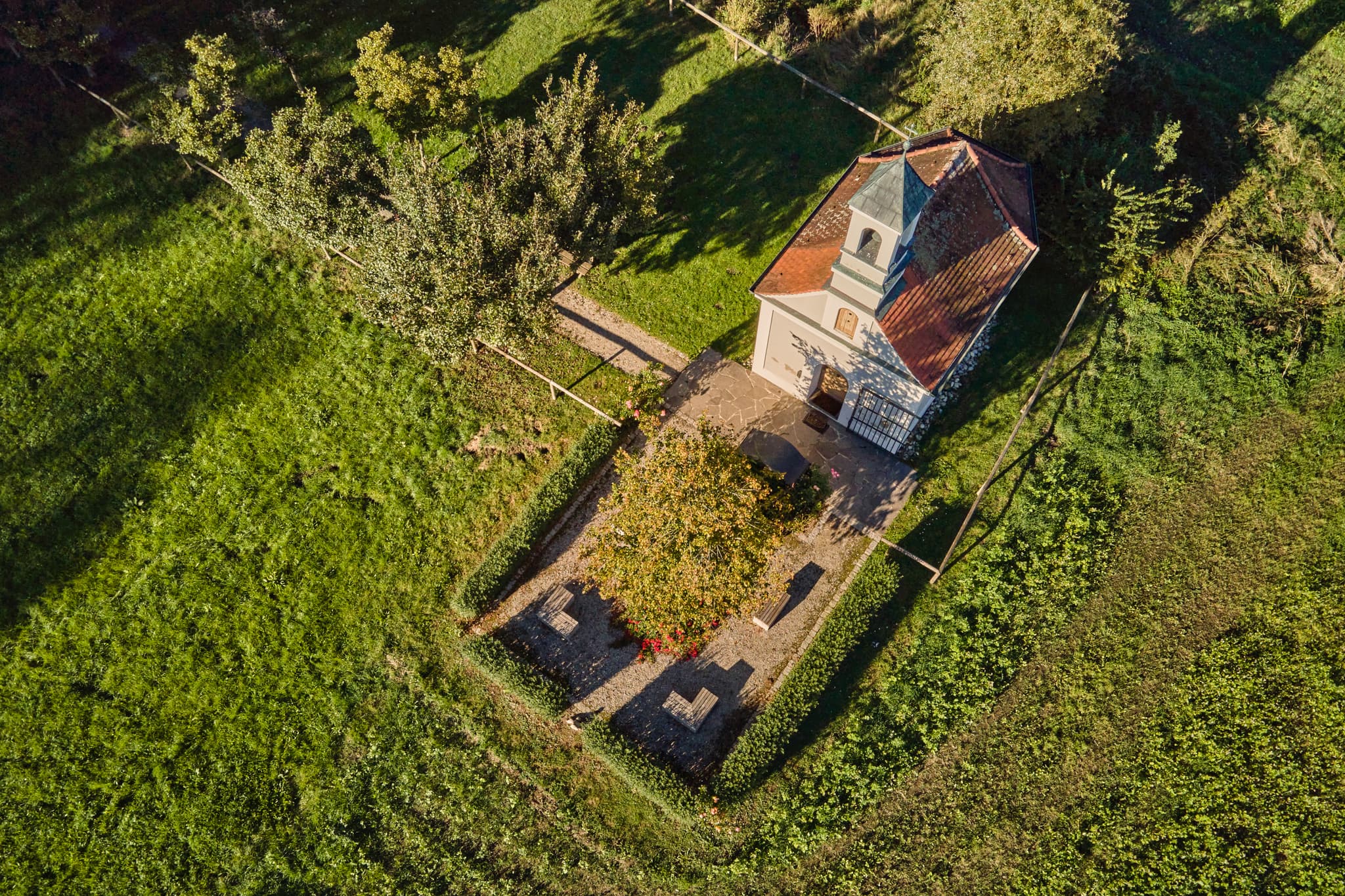 Luftaufnahme der Kapelle in Ecksberg Altmühldorf Kronwidl, Mühldorf am Inn, Oberbayern. Umgeben von grünen Wiesen und Bäumen, ein friedlicher Anblick.