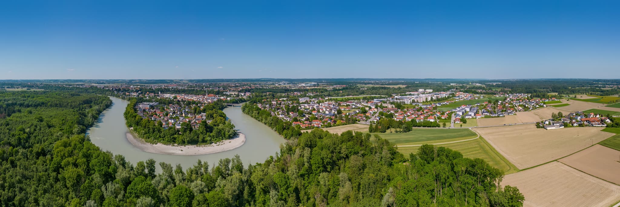 Dieses Luftbild zeigt die Stadt Mühldorf am Inn in Oberbayern, mit dem malerischen Inn, der sich durch die Landschaft schlängelt.