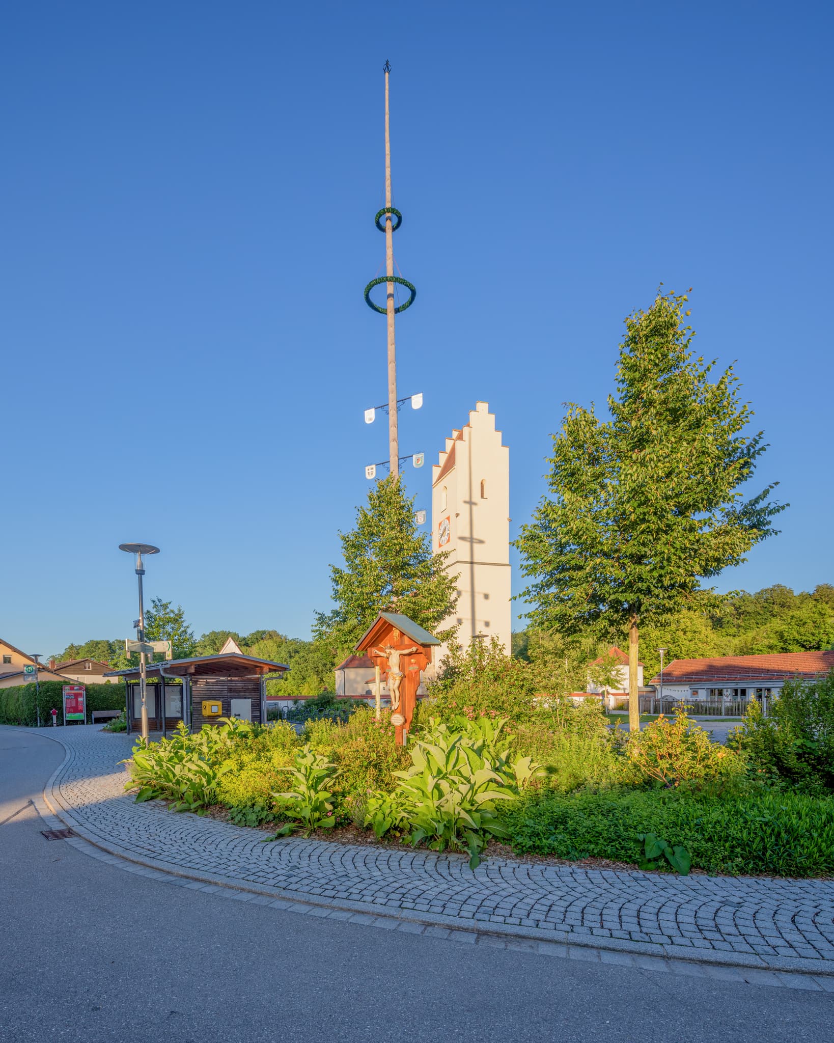 Herbstlandschaft in Neuoetting, Altötting, Oberbayern, Deutschland. Eine Kapelle steht unter einem großen Baum mit goldgelben Blättern.