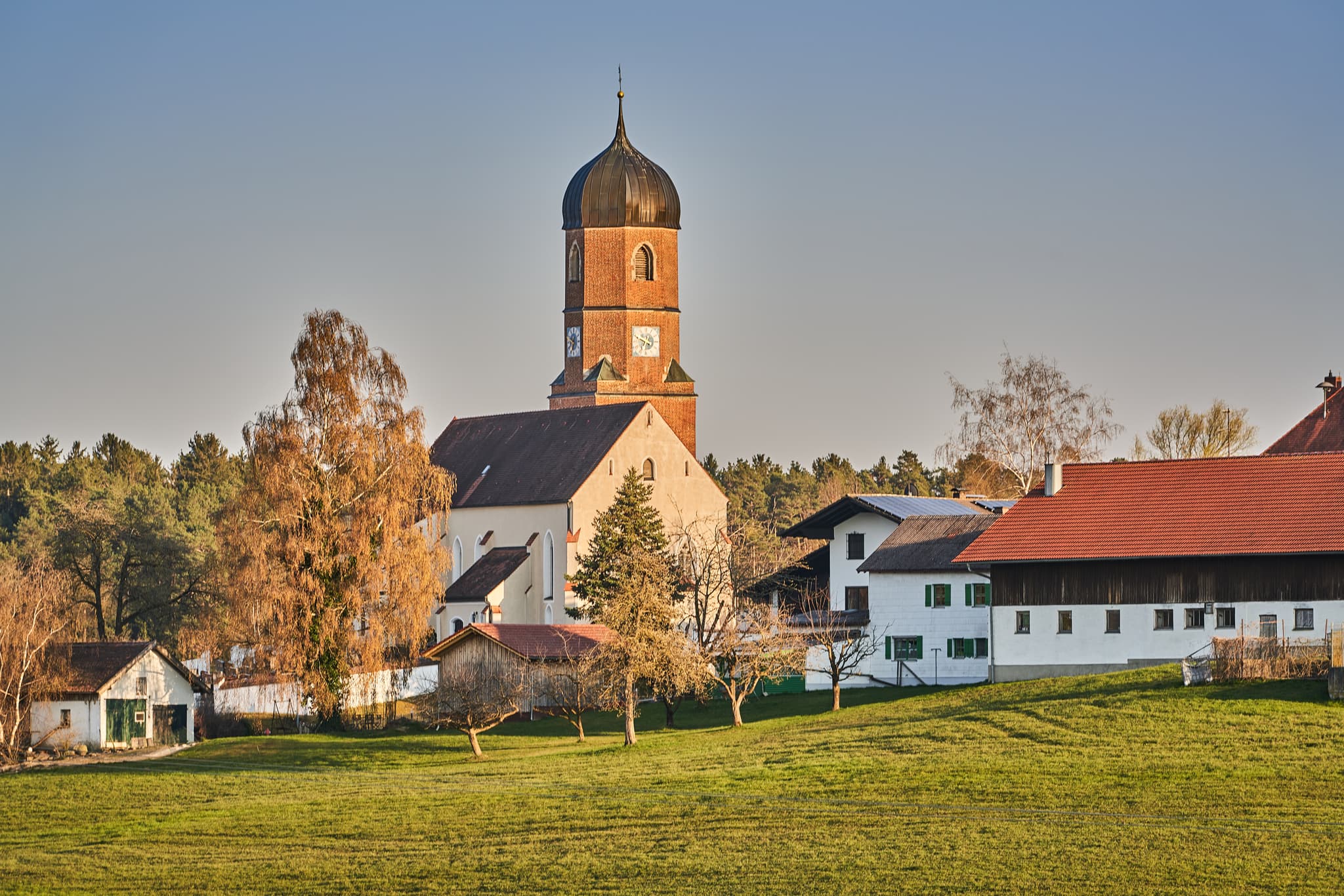 Kirche und Bauernhöfe mit Solaranlagen in Martinskirchen, Wurmannsquick, Landkreis Rottal-Inn, Niederbayern. Typische Landschaft des Holzlands, Deutschland.