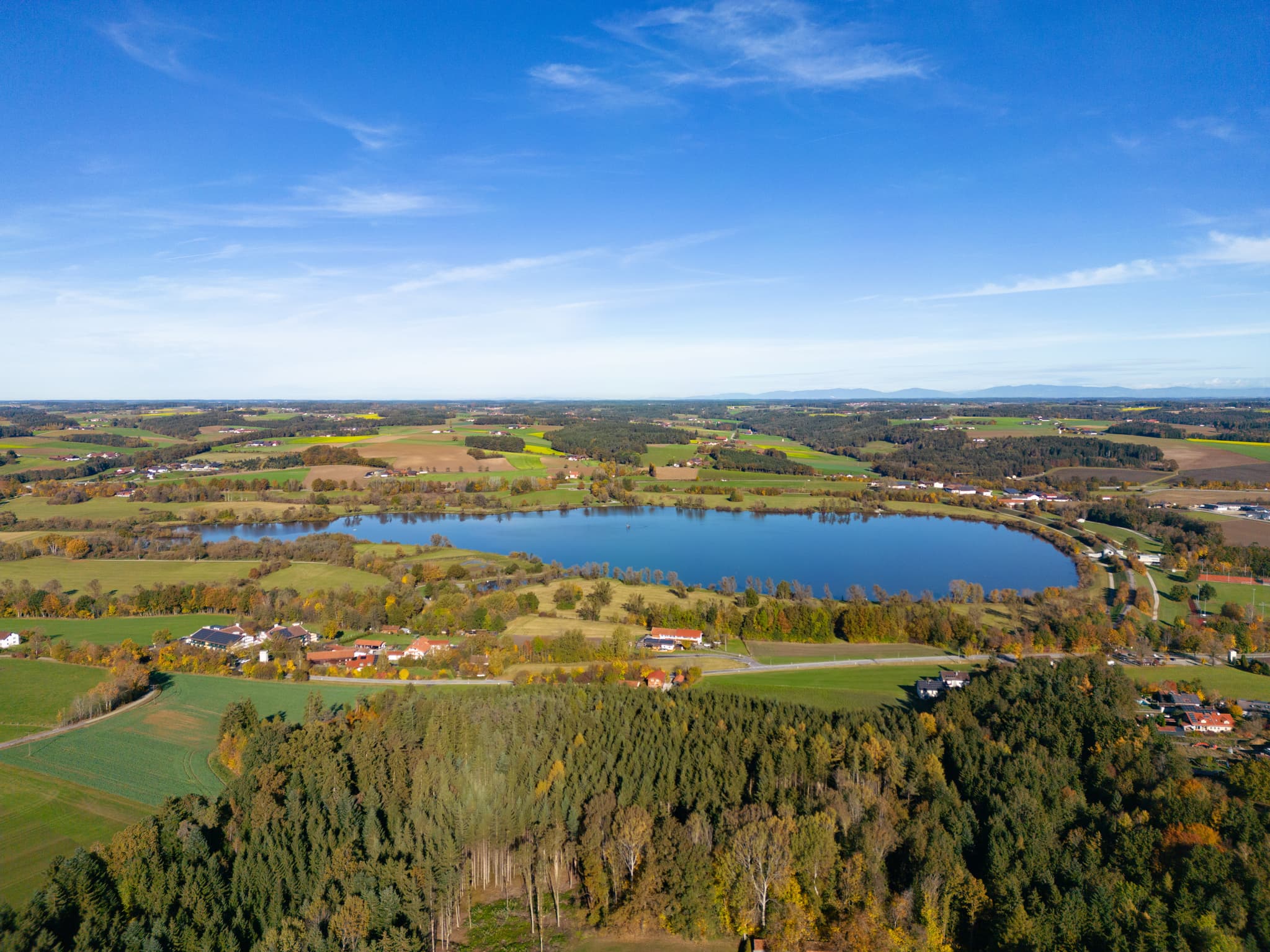 Stausee nahe Postmünster im Landkreis Rottal-Inn, Niederbayern. Die ländliche Region Holzland in Deutschland zeigt den See mit Wald und Feldern.