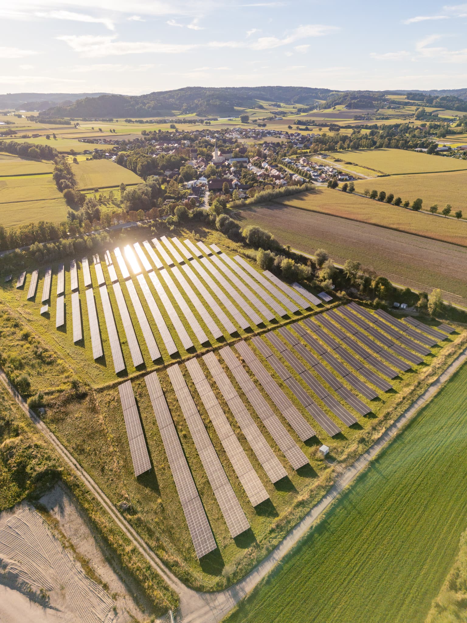 PV-Freiflächenanlage bei Ering am Inn im Landkreis Rottal-Inn, Niederbayern. Ländliche Umgebung im Holzland, Deutschland, mit Dorf und sanften Hügeln.