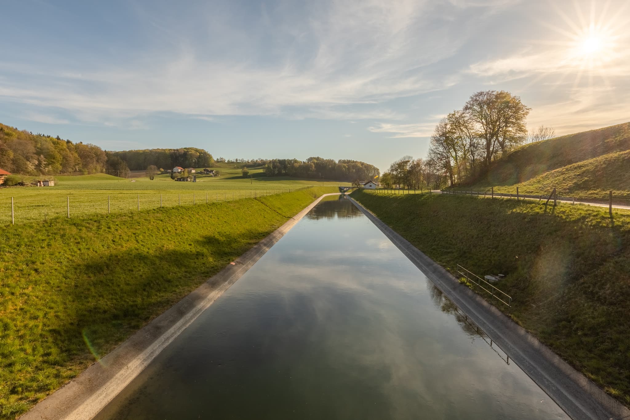 Alzkanals in Auberg, Hintermehring, Mehring, Landkreis Altötting, Oberbayern, Inn-Salzach, Deutschland, präsentiert grüne Wiesen und Hügel entlang des Kanals.