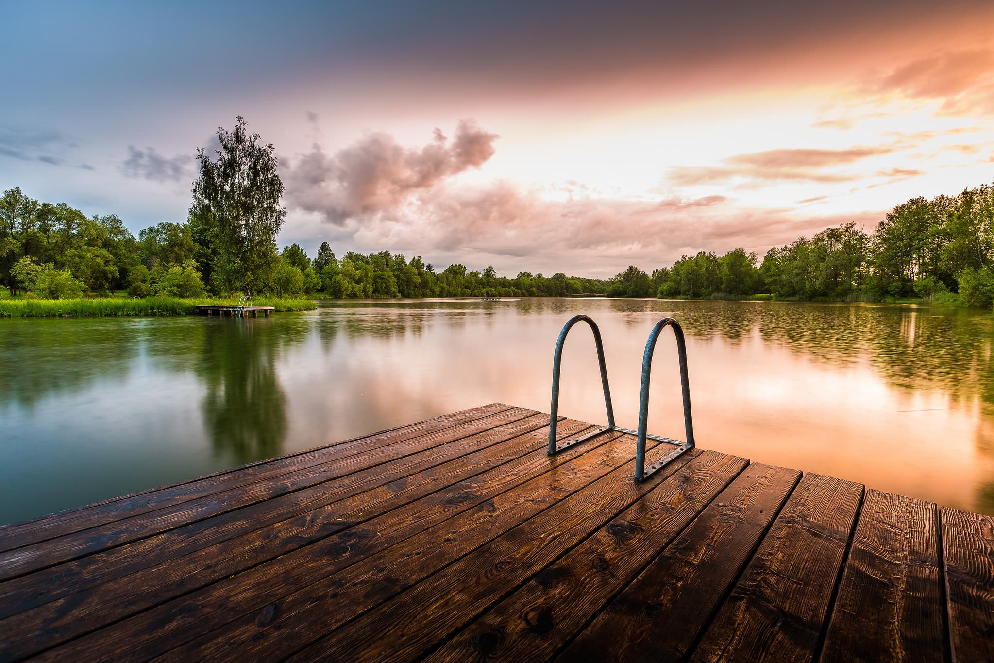 Idyllischer Badesee in Perach, Oberbayern, Inn-Salzach Region, Deutschland. Genießen Sie die Ruhe und Natur am Wasser. Holzsteg am See bei Sonnenuntergang.