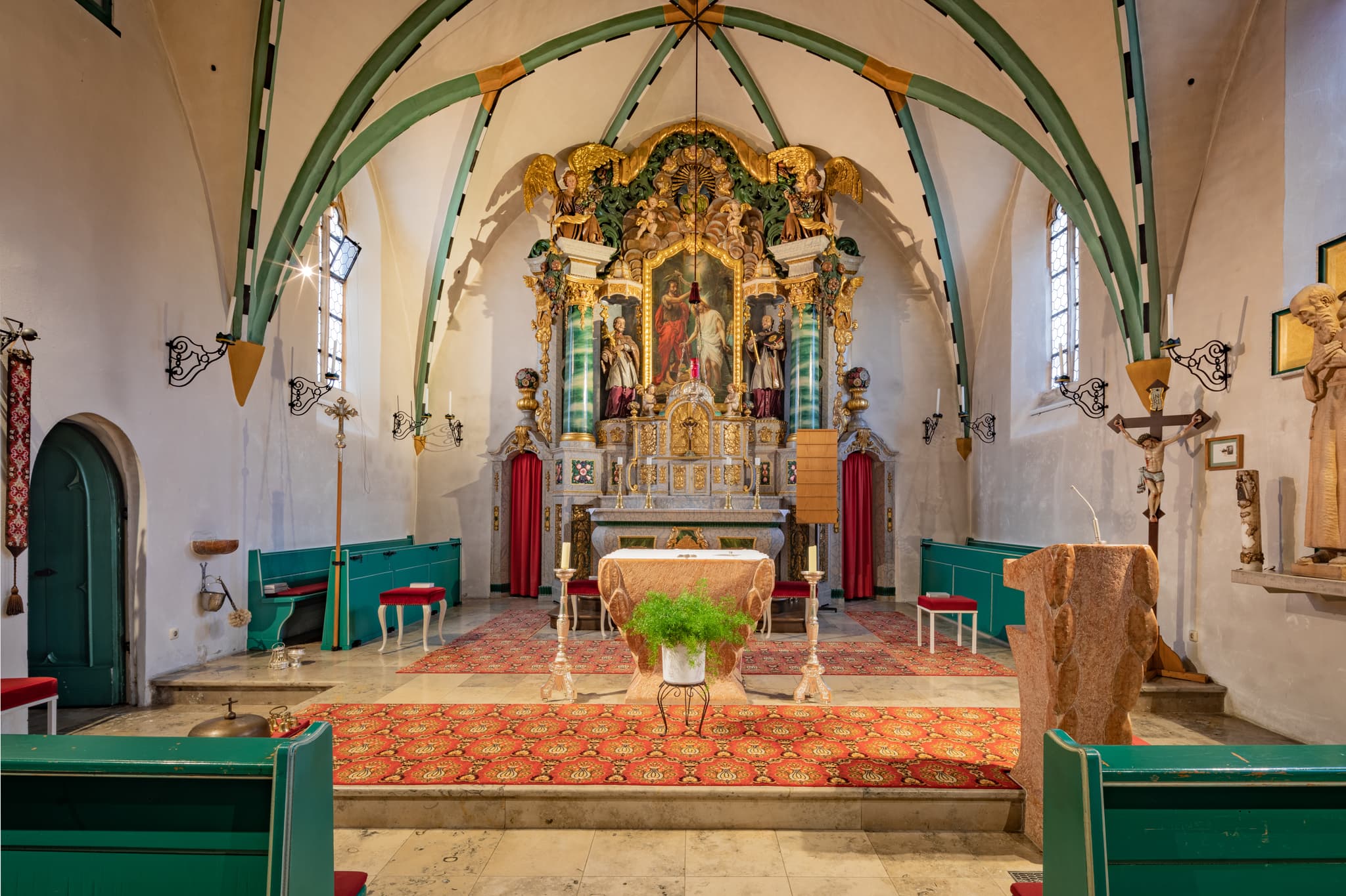Innenansicht der Pfarrkirche St. Johannes der Täufer in Weng, Bad Griesbach, Lkr. Passau, Niederbayern, Deutschland. Grünes Gestühl, Altarraum und Decke.