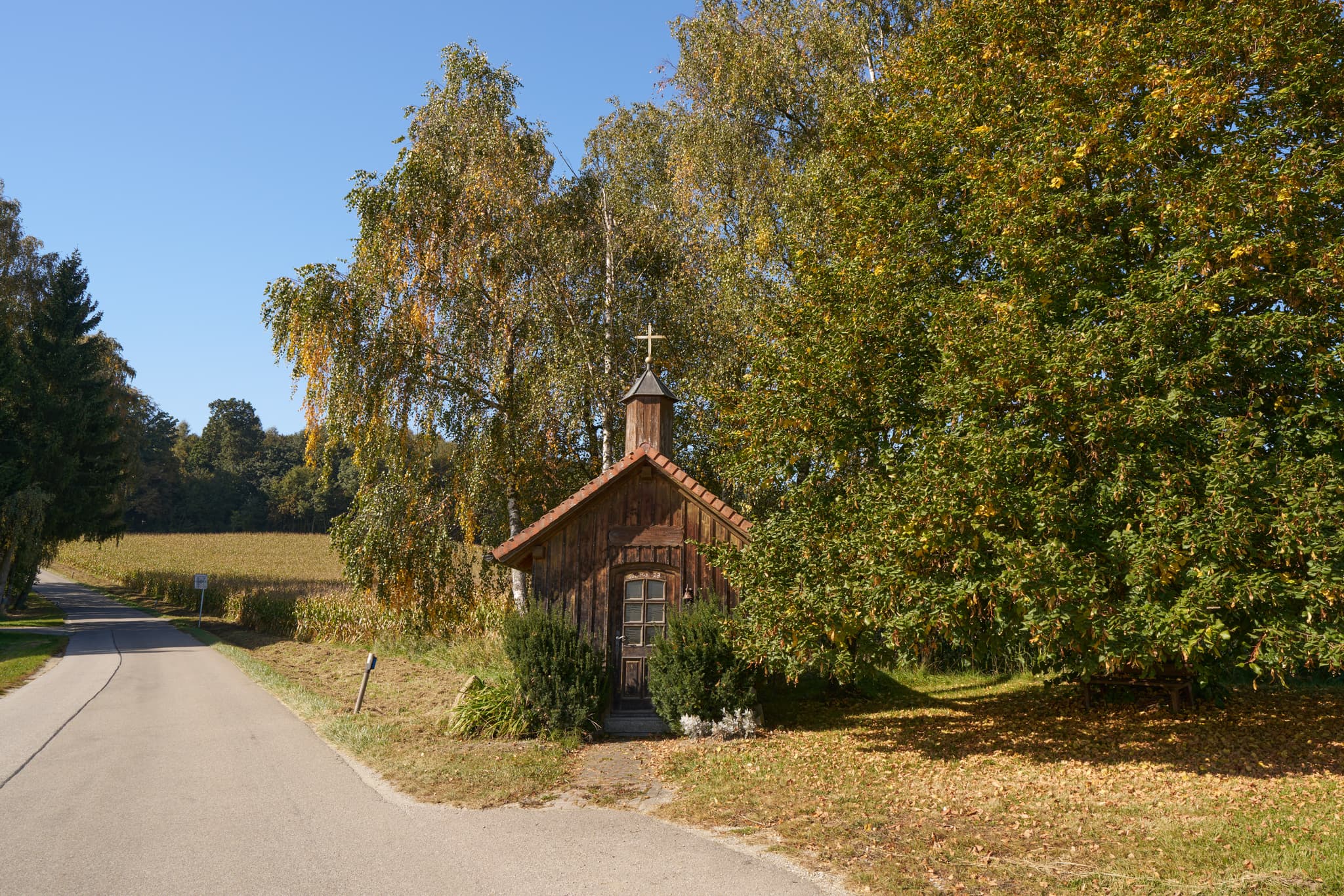 Holzkapelle in Stadlreith, Tettenweis. Landkreis Passau, Niederbayern, Deutschland. Umgeben von Bäumen und Feldern im Donau-Wald.