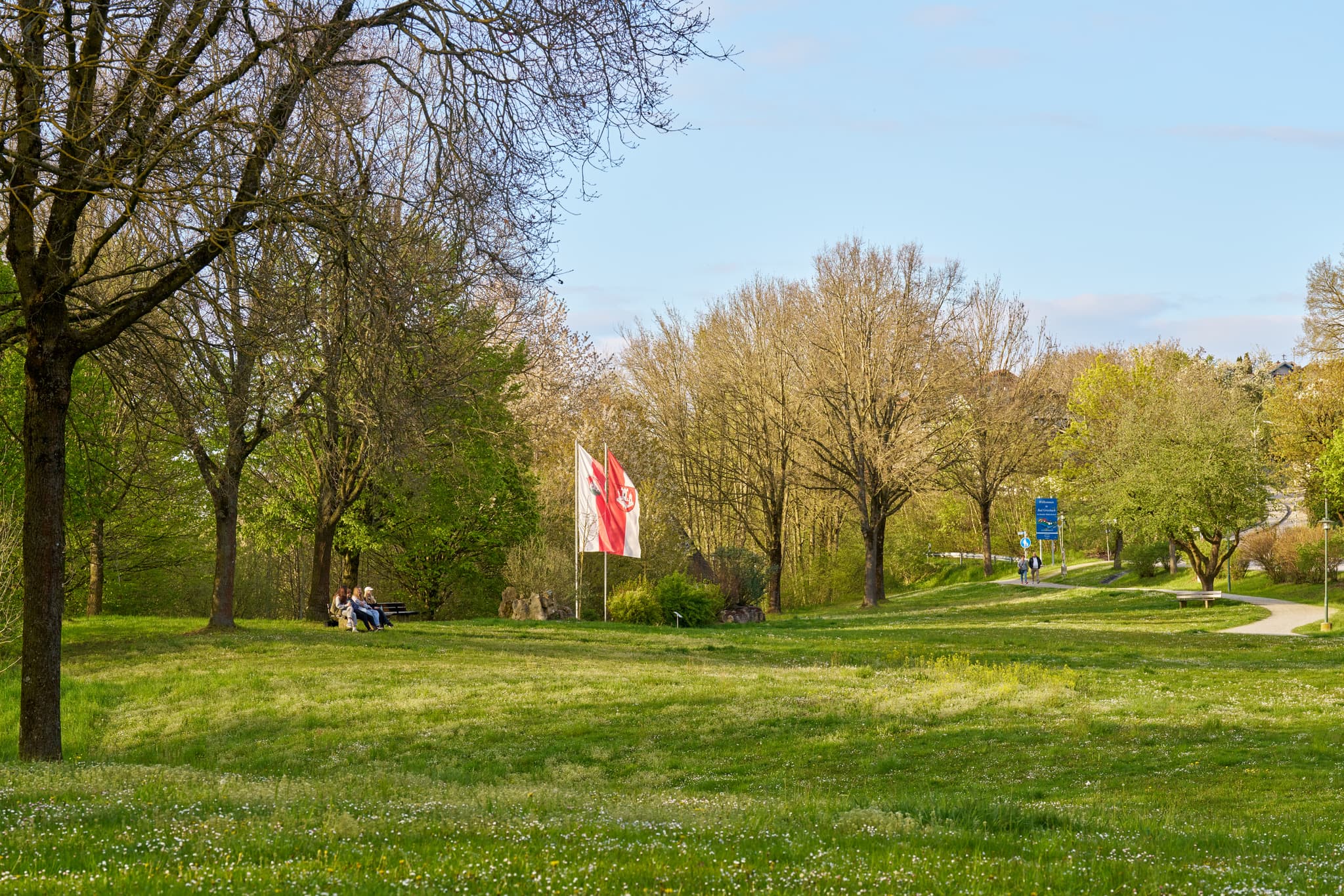 Parklandschaft in Bad Griesbach, Landkreis Passau, Niederbayern, Inn-Salzach, Bayern, Deutschland. Bäume, Wiese, Personen auf Bank.