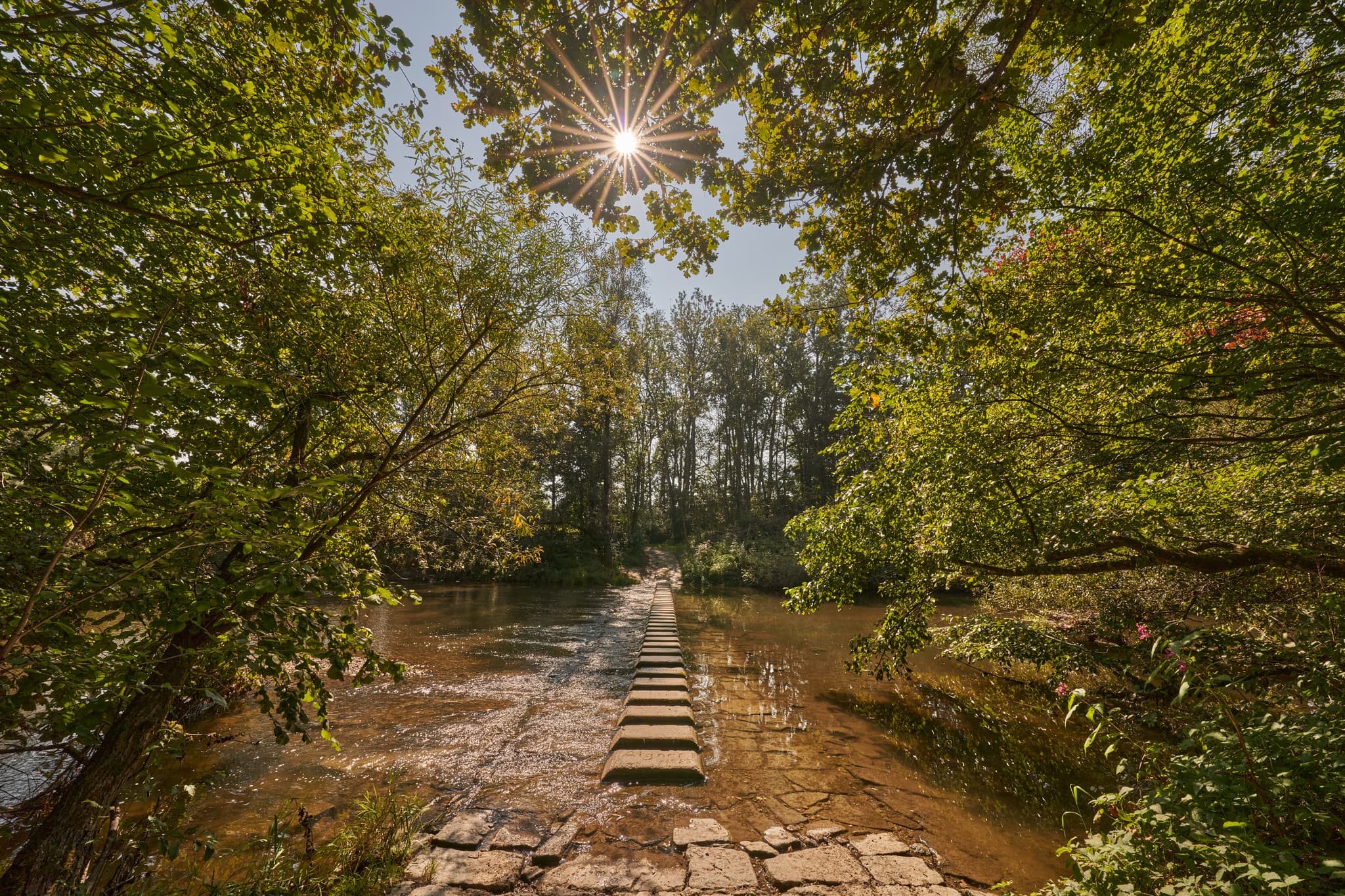 Lindloh Isen Pilgerweg in Winhöring, Altötting, Oberbayern, Deutschland. Malerischer Pfad mit Trittsteinen durch Fluss Isen im Inn-Salzach Gebiet.