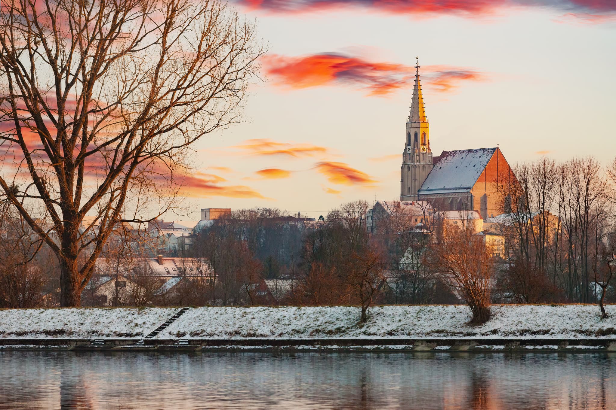 Winteransicht Neuötting am Inn, Landkreis Altötting, Oberbayern, Inn-Salzach, Deutschland. Die Landschaft zeigt schneebedeckte Ufer und einen farbigen Himmel.