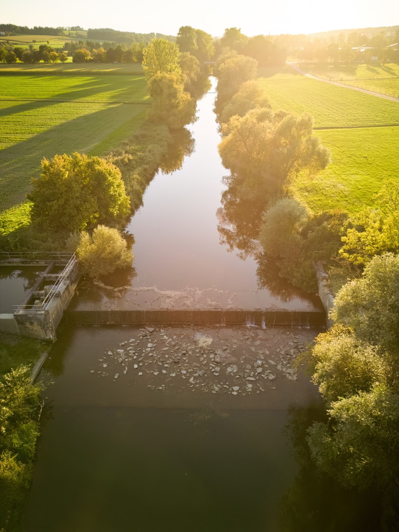 Wehr mit Wasserfall an der Rott bei Löfflmühle, Hebertsfelden, Landkreis Rottal-Inn, Niederbayern, Deutschland. Umgeben von grüner Natur im Holzland.