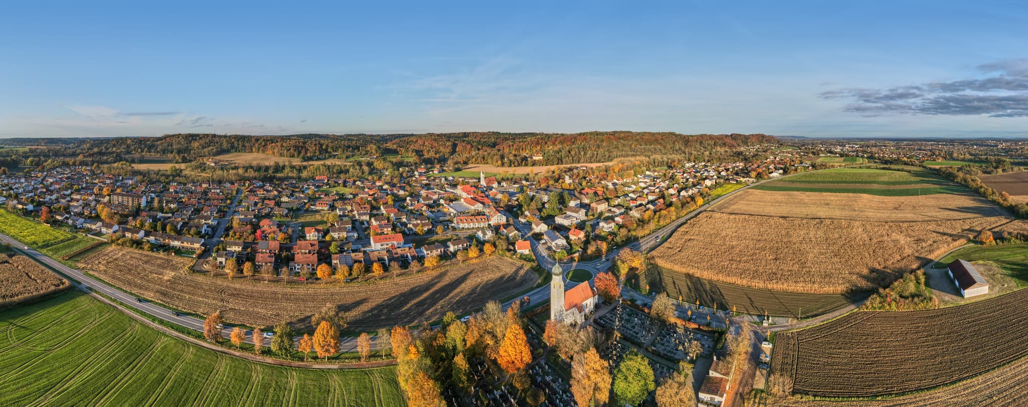 Luftbild-Panorama von Winhöring, Altötting, Oberbayern. Das Dorf liegt eingebettet in herbstliche Felder und Wälder der Region Inn-Salzach, Deutschland.