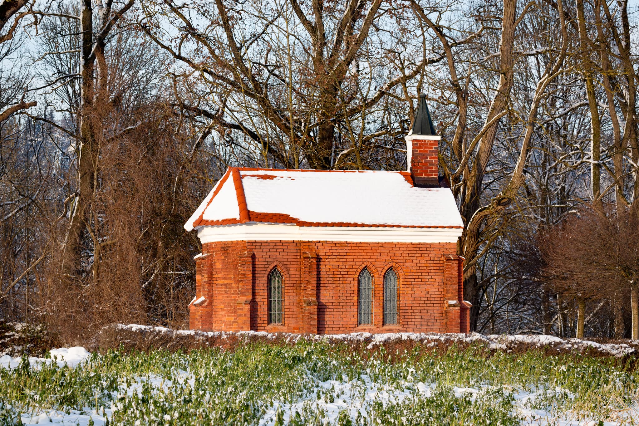 Winterliche Isen Kapelle in Winhöring, Landkreis Altötting, Oberbayern. Die Kapelle steht in der verschneiten Landschaft der Region Inn-Salzach, Deutschland.