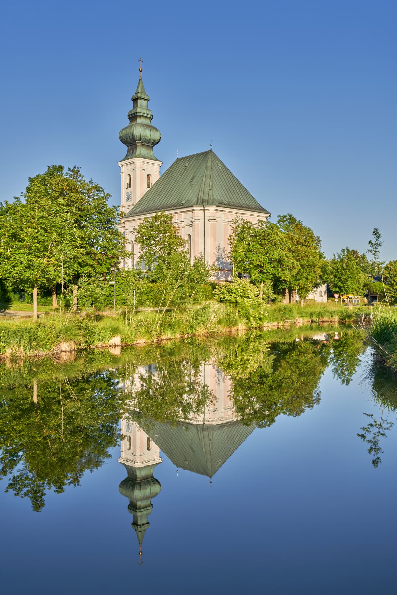 Die Dorfweiher Kirche in Kirchweidach, Landkreis Altötting, Oberbayern, besticht durch ihre Lage am Dorfweiher. Inn-Salzach Region, Deutschland.