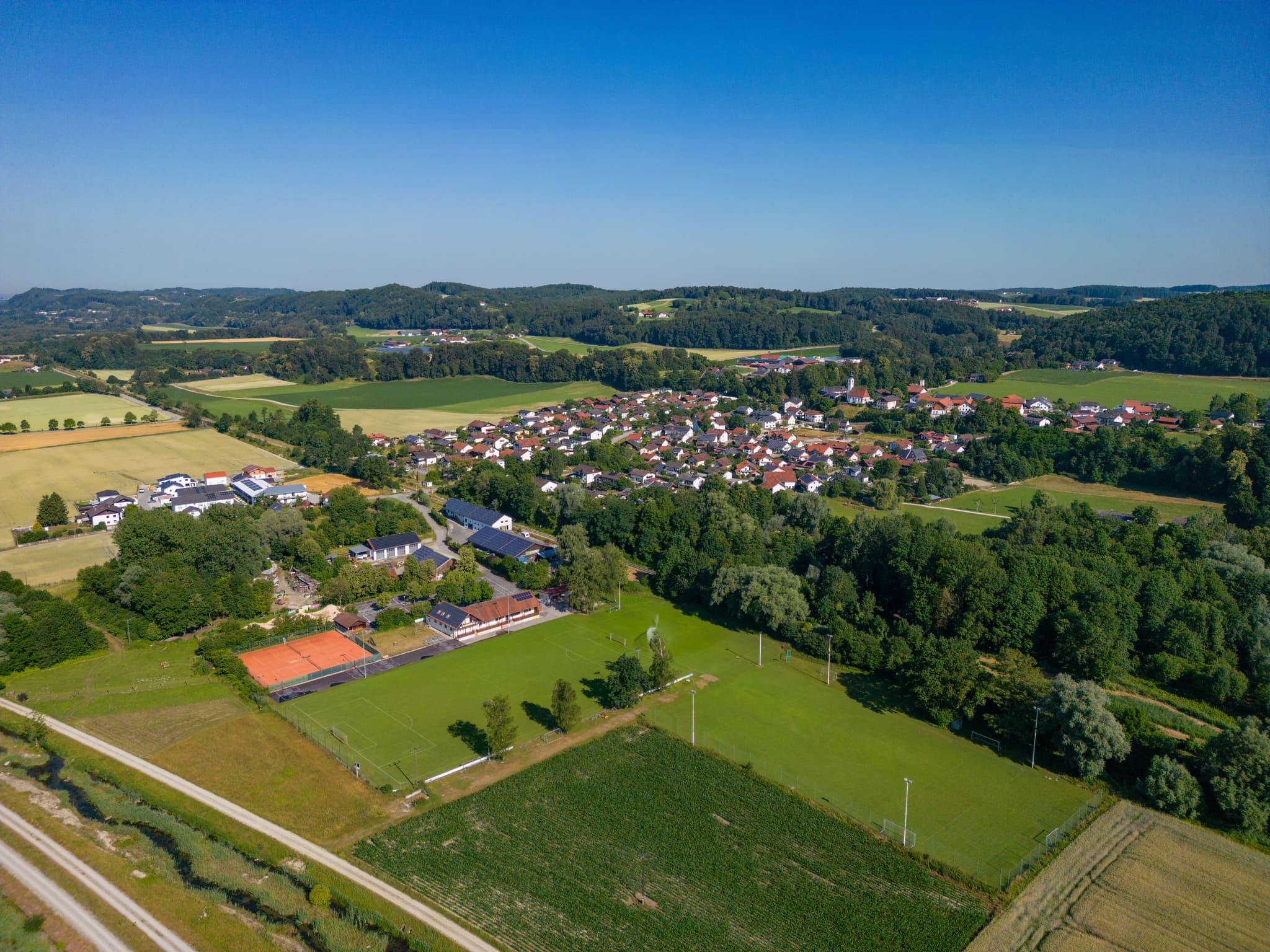 Luftbild von Perach, Landkreis Altötting, Oberbayern. Die Gemeinde liegt in der Region Inn-Salzach, Deutschland. Es zeigt Häuser, Felder und Wälder.