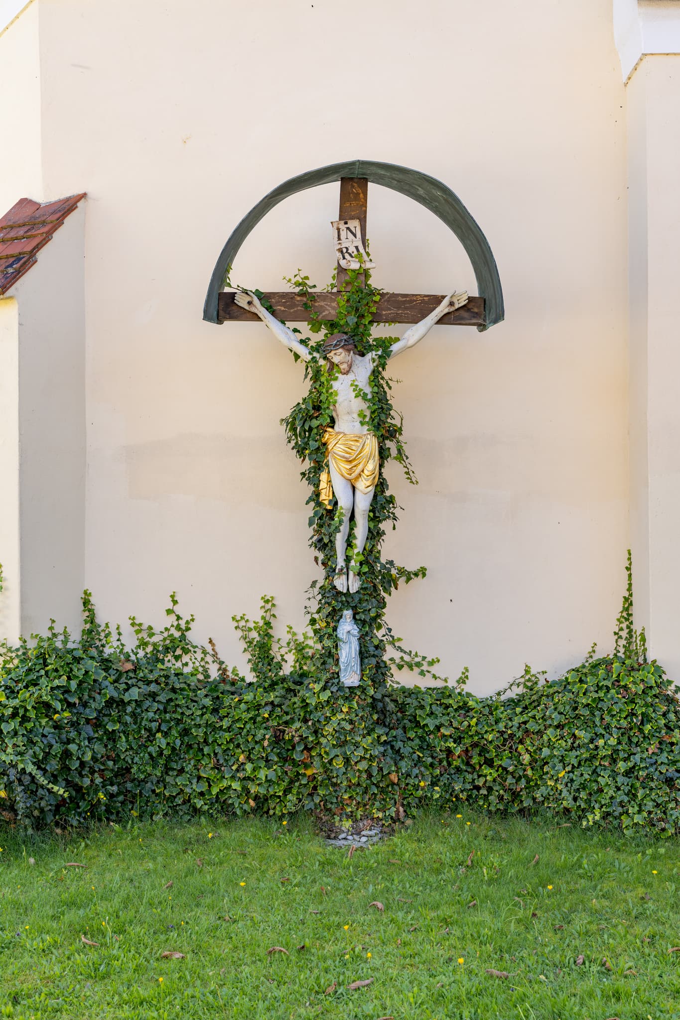 Kruzifix mit Efeu an Wand in Guteneck, Johanniskirchen. Landkreis Rottal-Inn, Niederbayern, Deutschland. Prägt religiöse Tradition im Holzland.