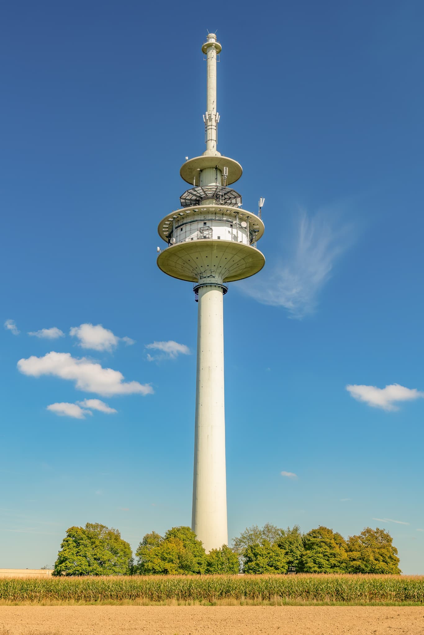 Funkturm, Fernsehturm in Schnaitsee, Landkreis Traunstein, Oberbayern, Deutschland. Das Bauwerk prägt die Region Chiemgau mit Feldern und blauem Himmel.