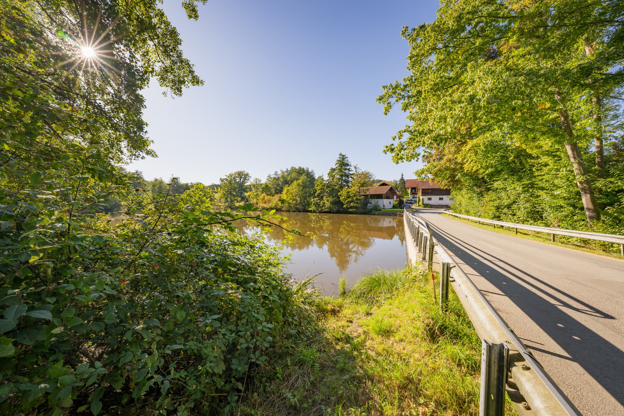Weiher in Baumgarten, Dietersburg, Rottal-Inn, Niederbayern. Eine Straße führt am Ufer entlang, Natur im Bäderdreieck, Deutschland.