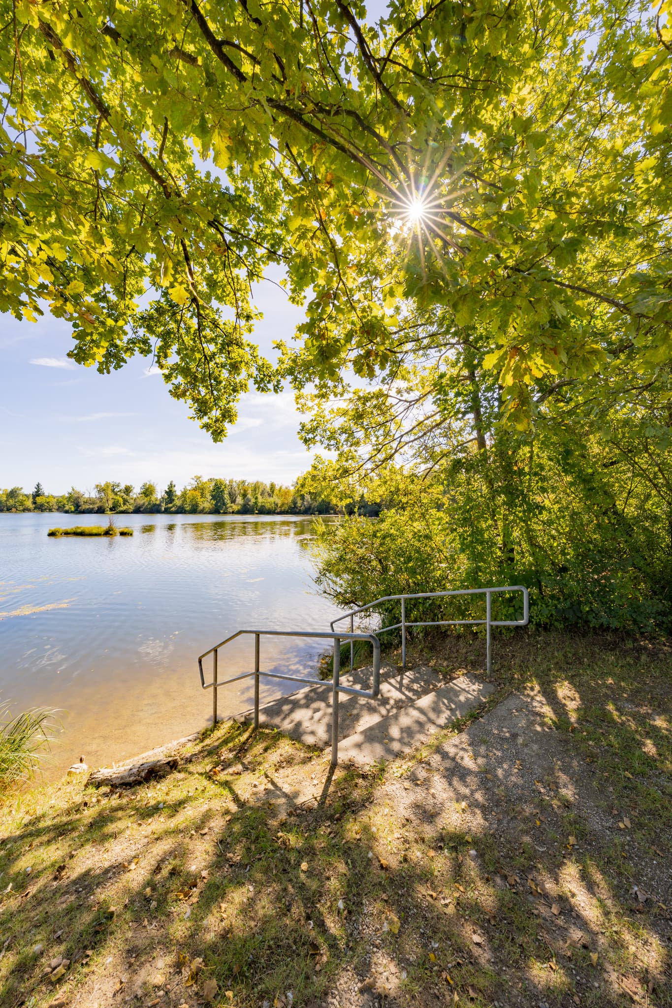 Sommertag am Waldsee Lago, Badesee Simbach, Kirchdorf am Inn, Rottal-Inn. Badetreppe führt ins klare Wasser. Natur im Holzland, Niederbayern, Deutschland.