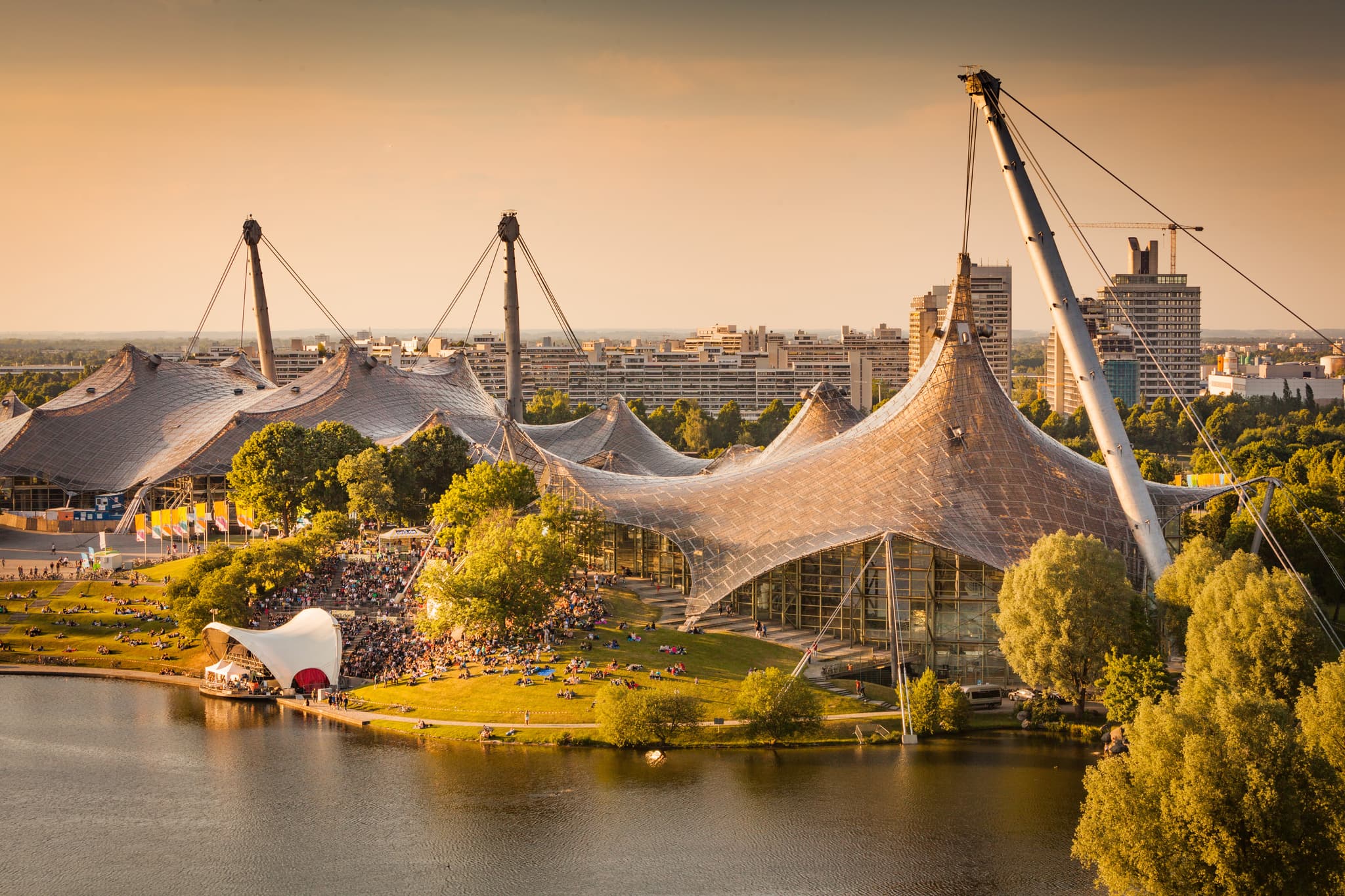 Der Olympiapark in München, Oberbayern, Deutschland. Zeltarchitektur prägt diese weitläufige Sport- und Erholungslandschaft mit See und Grünflächen.