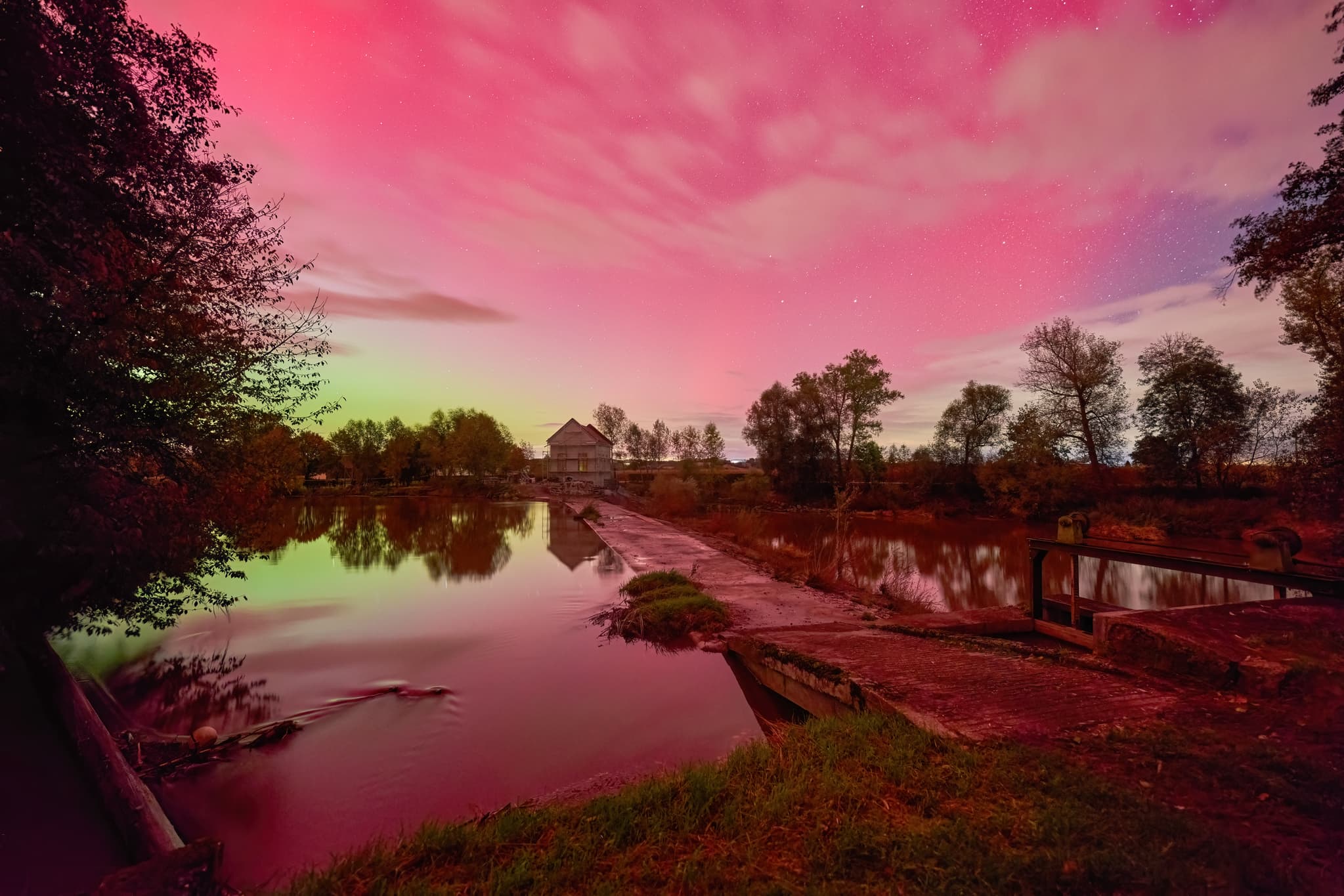 Polarlichter bei Voitl in der Au, Gemeinde Bayerbach, Landkreis Rottal-Inn, Niederbayern. Himmel leuchtet über der Rott und Landschaft im Holzland, Deutschland.
