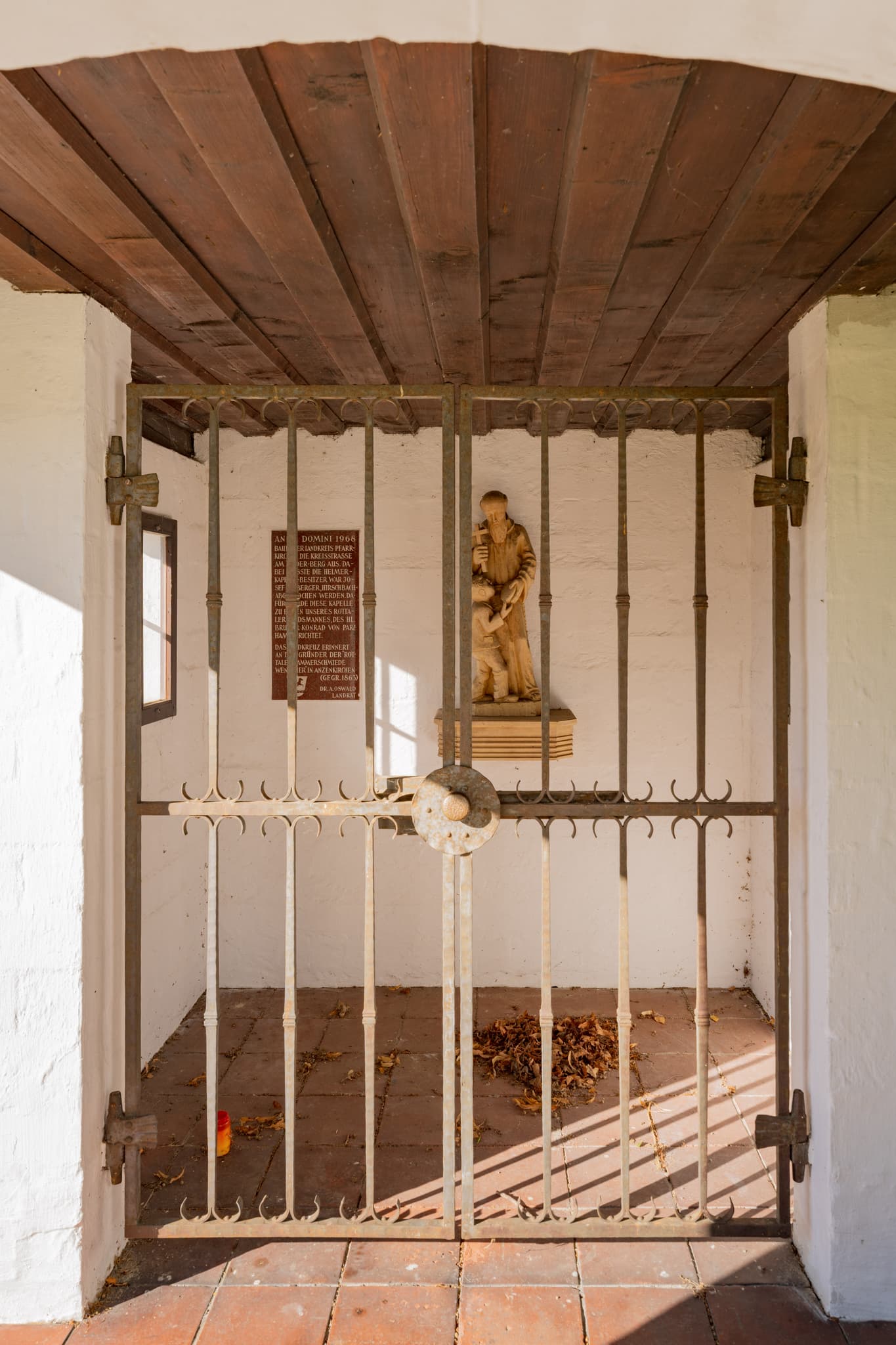 Bruder Konrad Kapelle bei Hirschbach, Bad Birnbach, Rottal-Inn, Niederbayern. Statue hinter schmiedeeisernem Tor in der Region Bäderdreieck, Deutschland.
