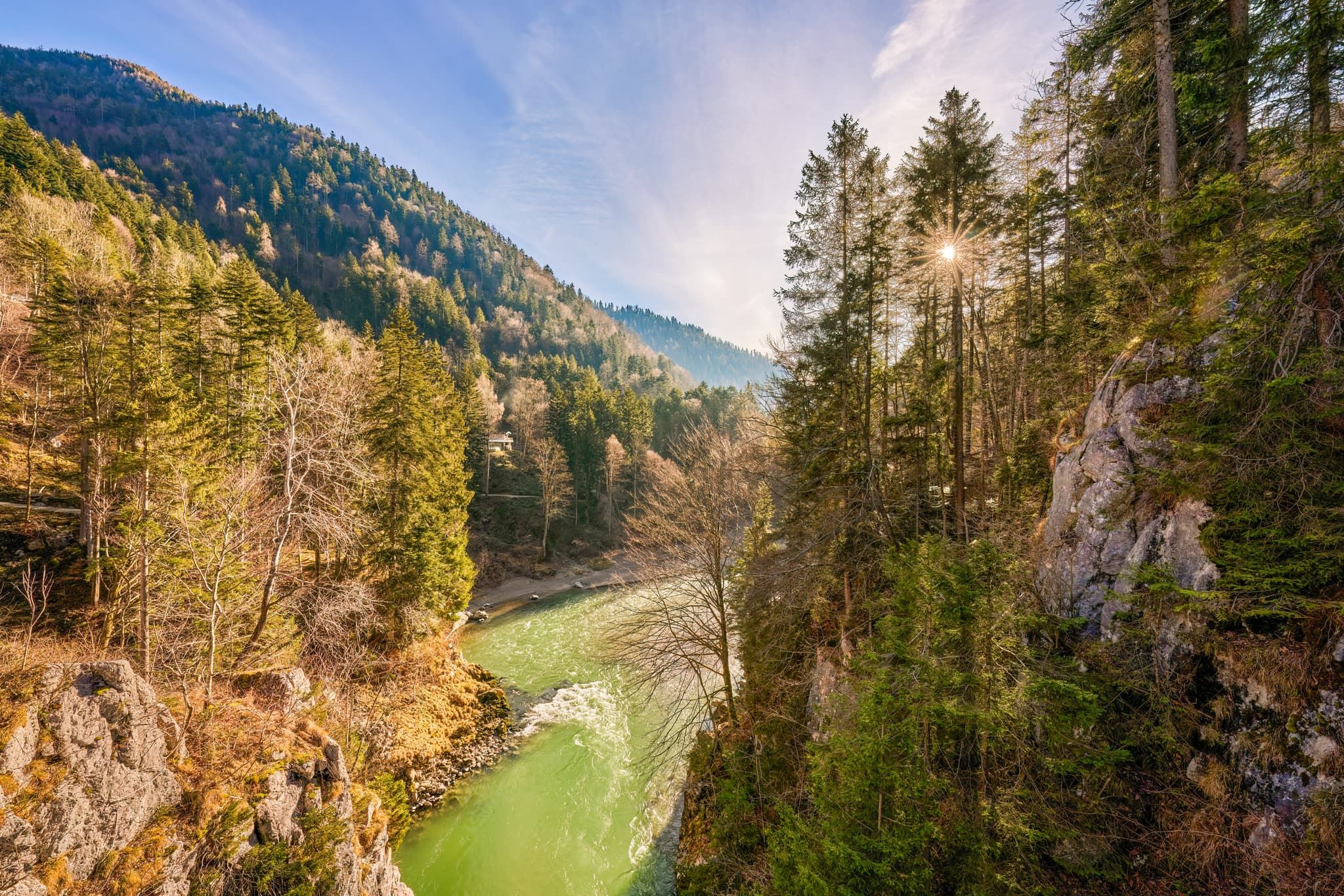 Fluss Tiroler Ache im bewaldeten Tal bei Klobenstein, Gemeinde Kössen, Kitzbühel, Tirol, Österreich. Landschaft der Kitzbüheler Alpen Schlucht im Sonnenlicht.