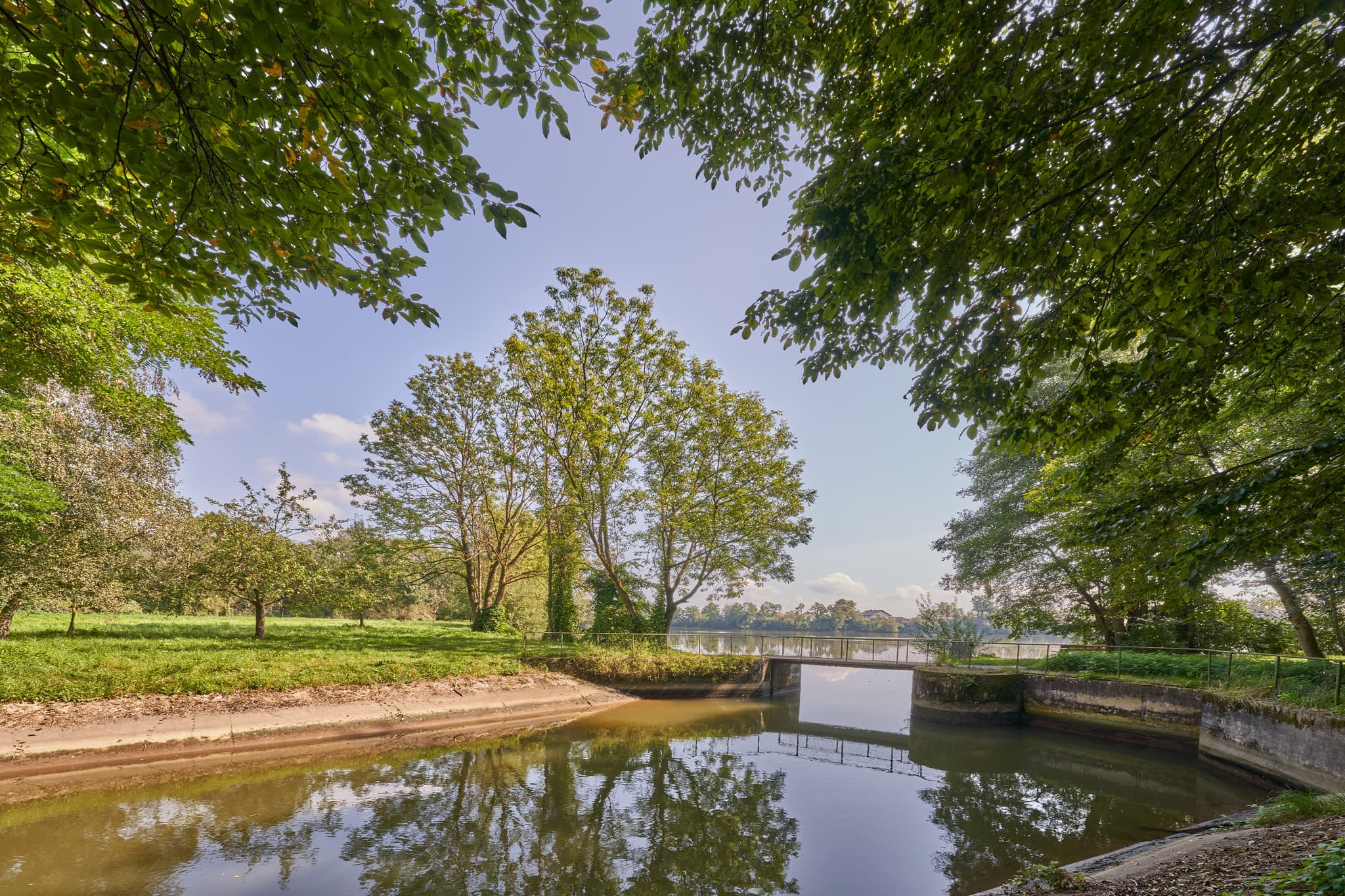 Ruhiger Isenkanal führt zum Stausee in Winhöring, Altötting, Oberbayern. Idyllische Naturlandschaft der Region Inn-Salzach in Deutschland mit Grün und Wasser.