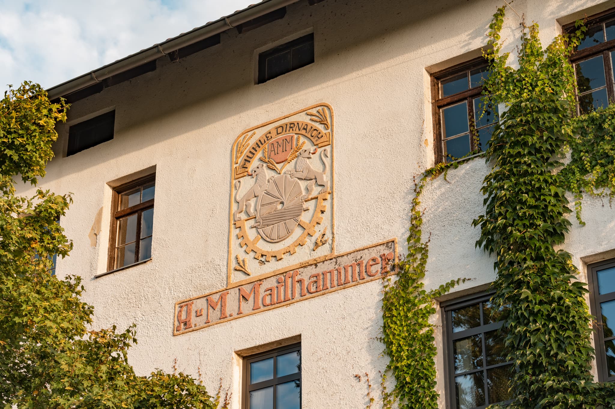 Historische Mühlenfassade mit Rankpflanzen in Dirnaich, einem Ortsteil von Gangkofen im Landkreis Rottal-Inn, Niederbayern. Gelegen im Holzland, Deutschland.