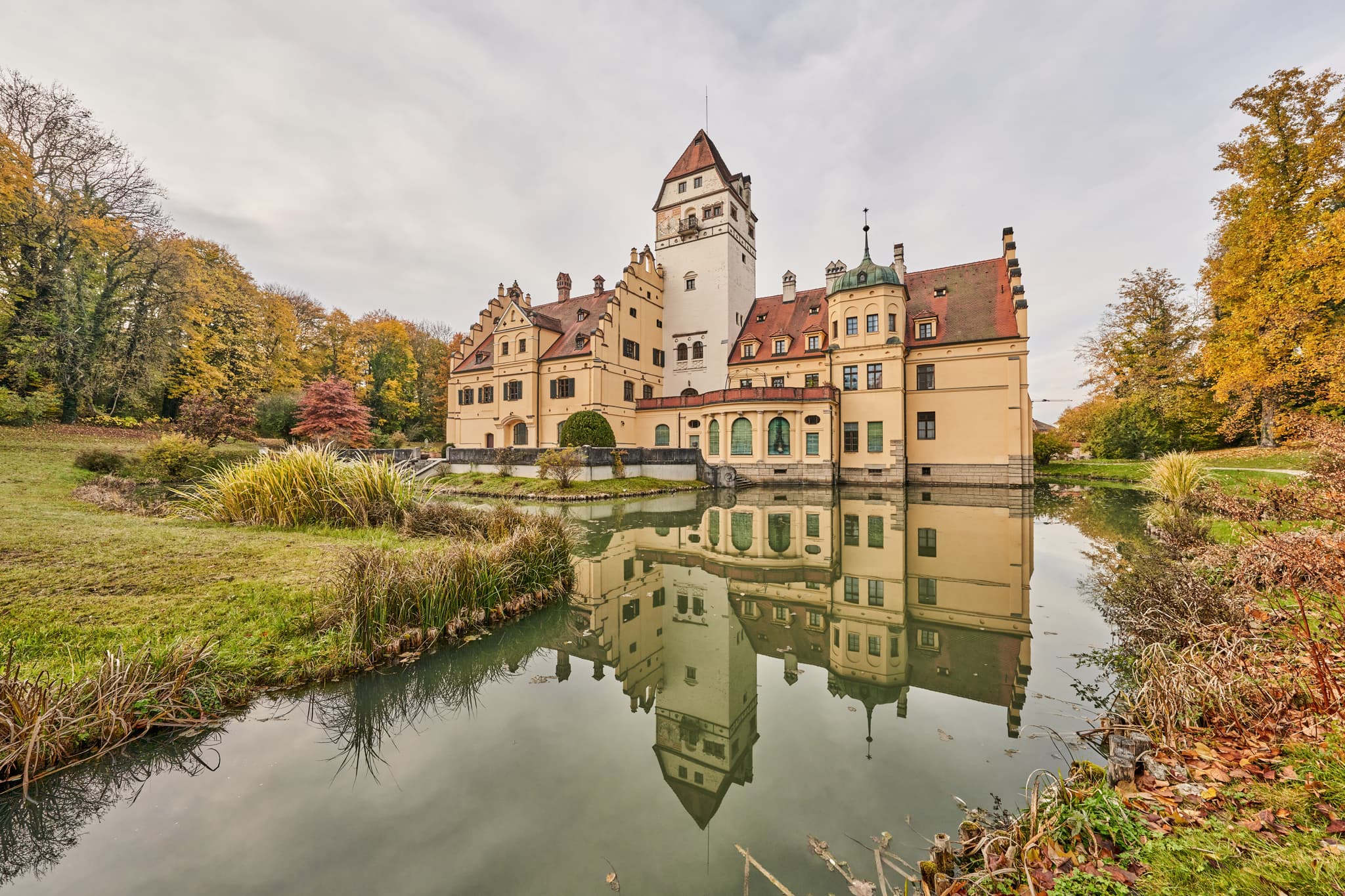 Schloss Schönau, Rottal-Inn, Niederbayern. Bauwerk mit Schlosspark und Wassergraben, spiegelt sich im Wasser. Herbstliche Natur im Holzland, Deutschland.