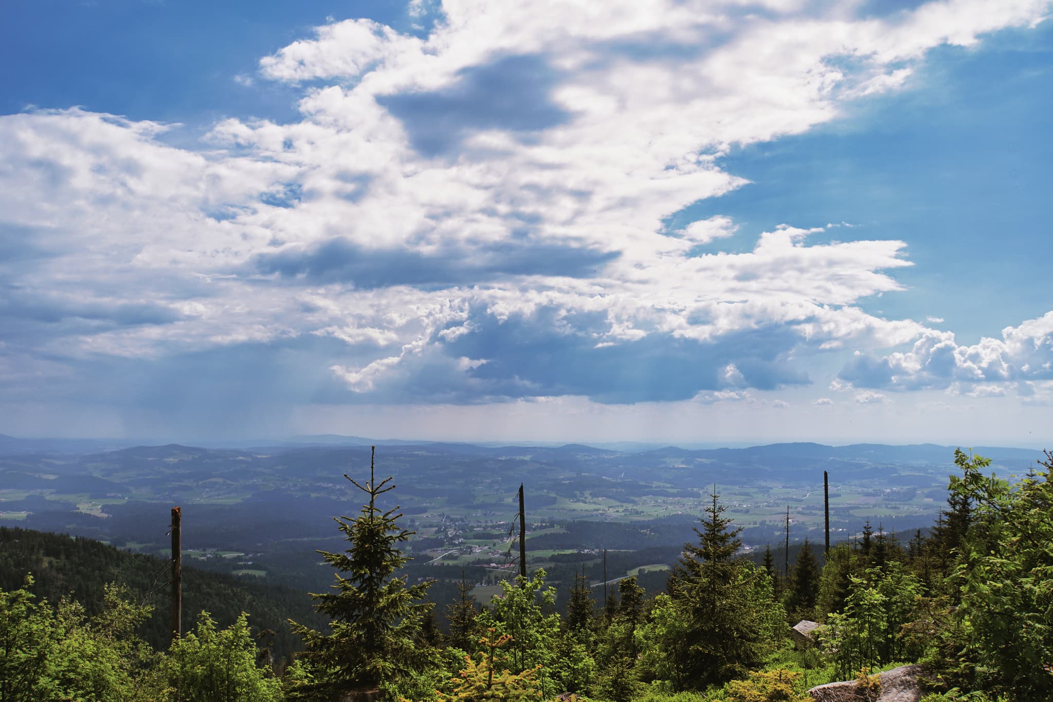 Blauer Himmel mit weißen Wolken dominiert das Bild. Die Stimmung ist ruhig und friedlich. Ein wunderschöner Panoramablick, der zum Träumen einlädt.