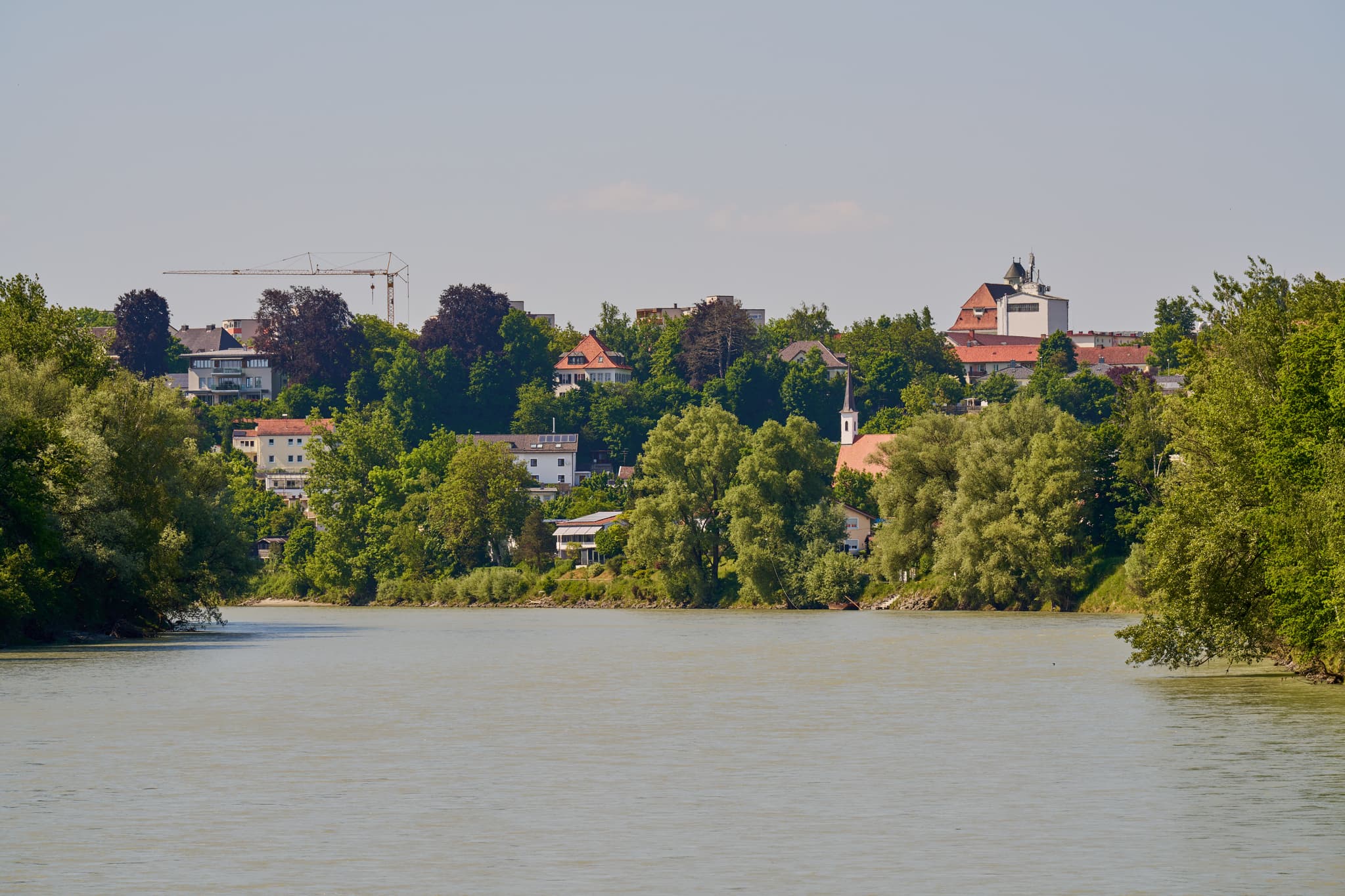 Der Inn in Mühldorf am Inn, Oberbayern, Deutschland, zeigt den Naturerlebnisweg Innaue. Stadt Mühldorf mit Gebäuden und Kirche prägt die Inn-Salzach Region.