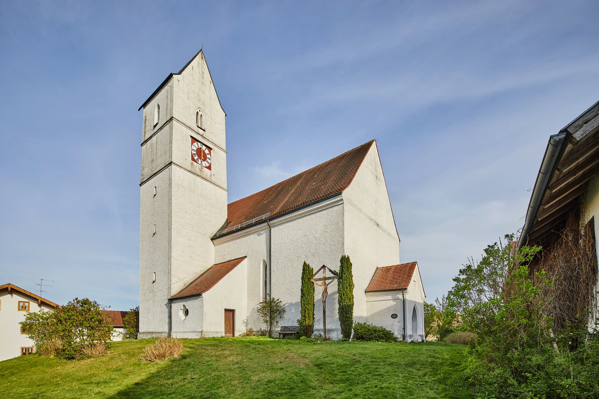 Außenansicht der Nebenkirche St. Stephan in Ecking, Reischach, Altötting, Oberbayern, Deutschland. Kirche auf grünem Hügel im Holzland.