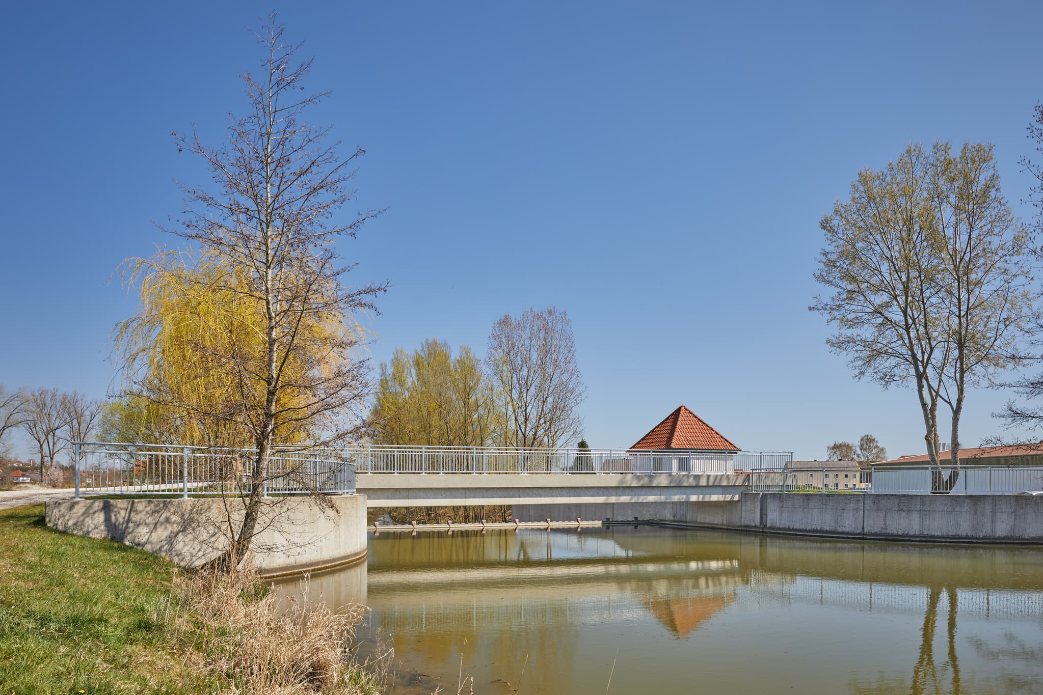 Brücke über die Rott, Unterdietfurt im Landkreis Rottal-Inn, Region Holzland, Niederbayern, Deutschland. Die ruhige Landschaft spiegelt Bäume wider.