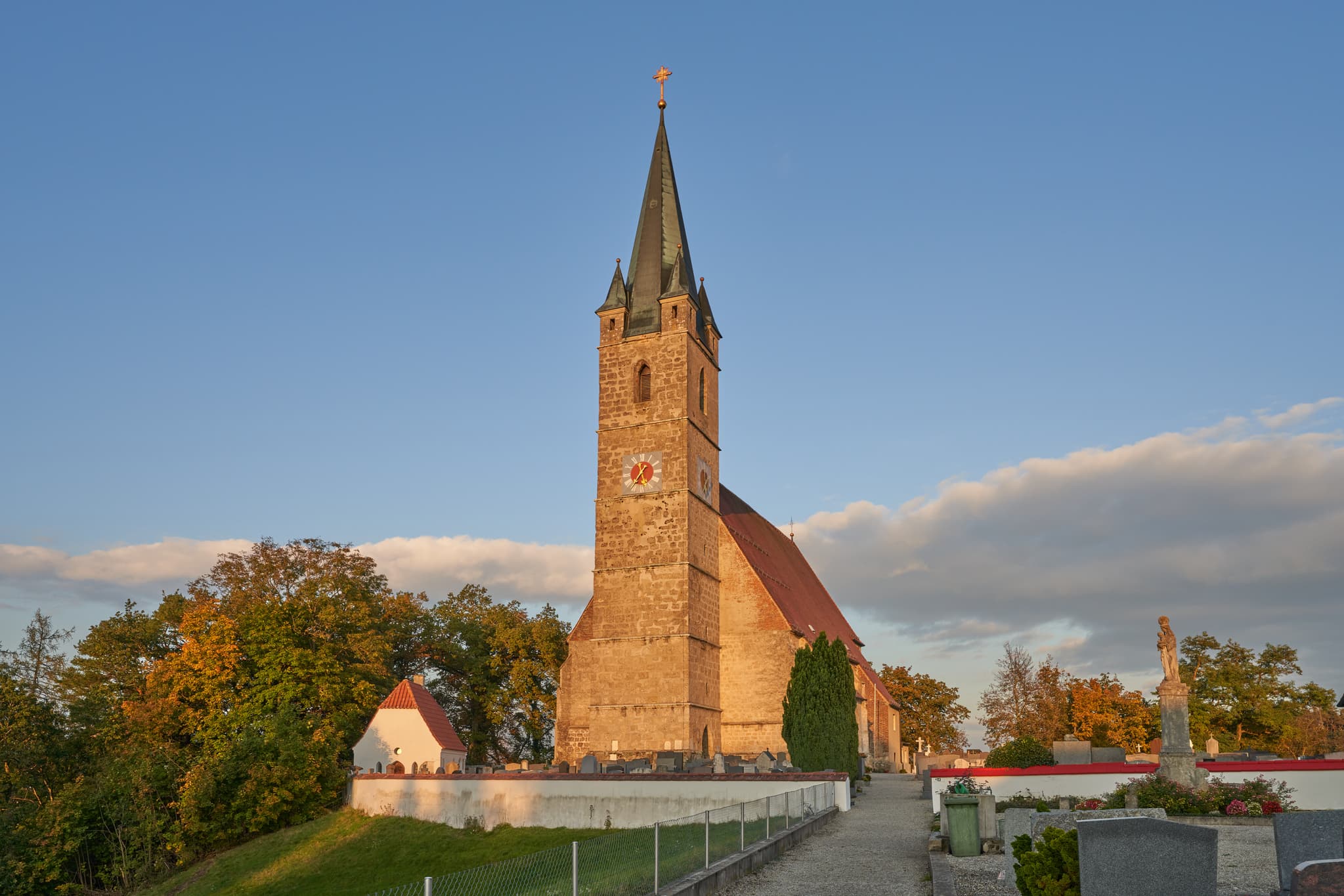 Pfarrkirche St. Rupertus in Burgkirchen am Wald, Tüßling, Altötting, Oberbayern, Deutschland. Kirche, Turm, Friedhof im Abendlicht.