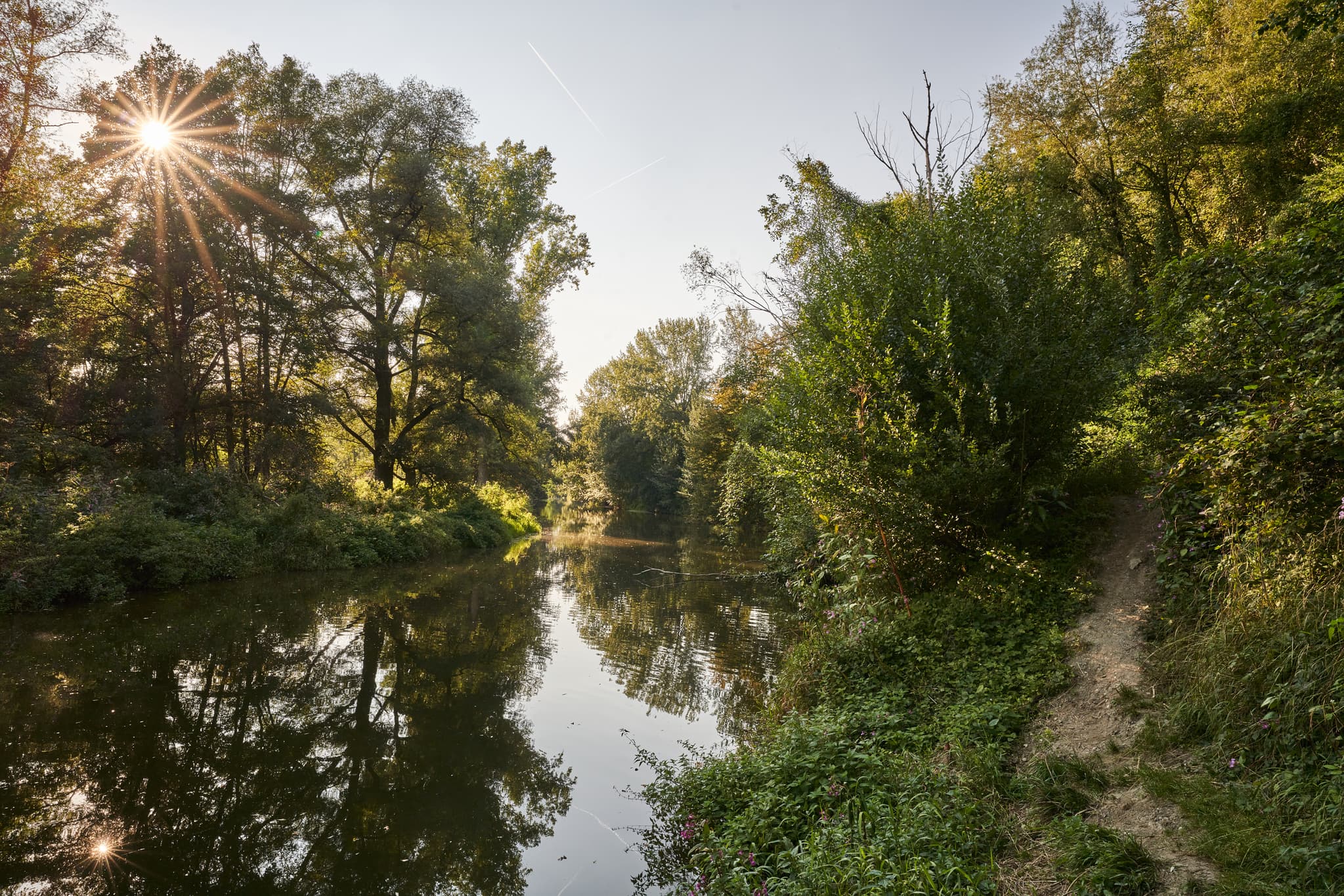 Natürliche Wasserlandschaft an der Isen bei Steinhöring, Winhöring. Grünes Ufer, Bäume, Spiegelungen im Fluss. Landkreis Altötting, Oberbayern, Inn-Salzach.