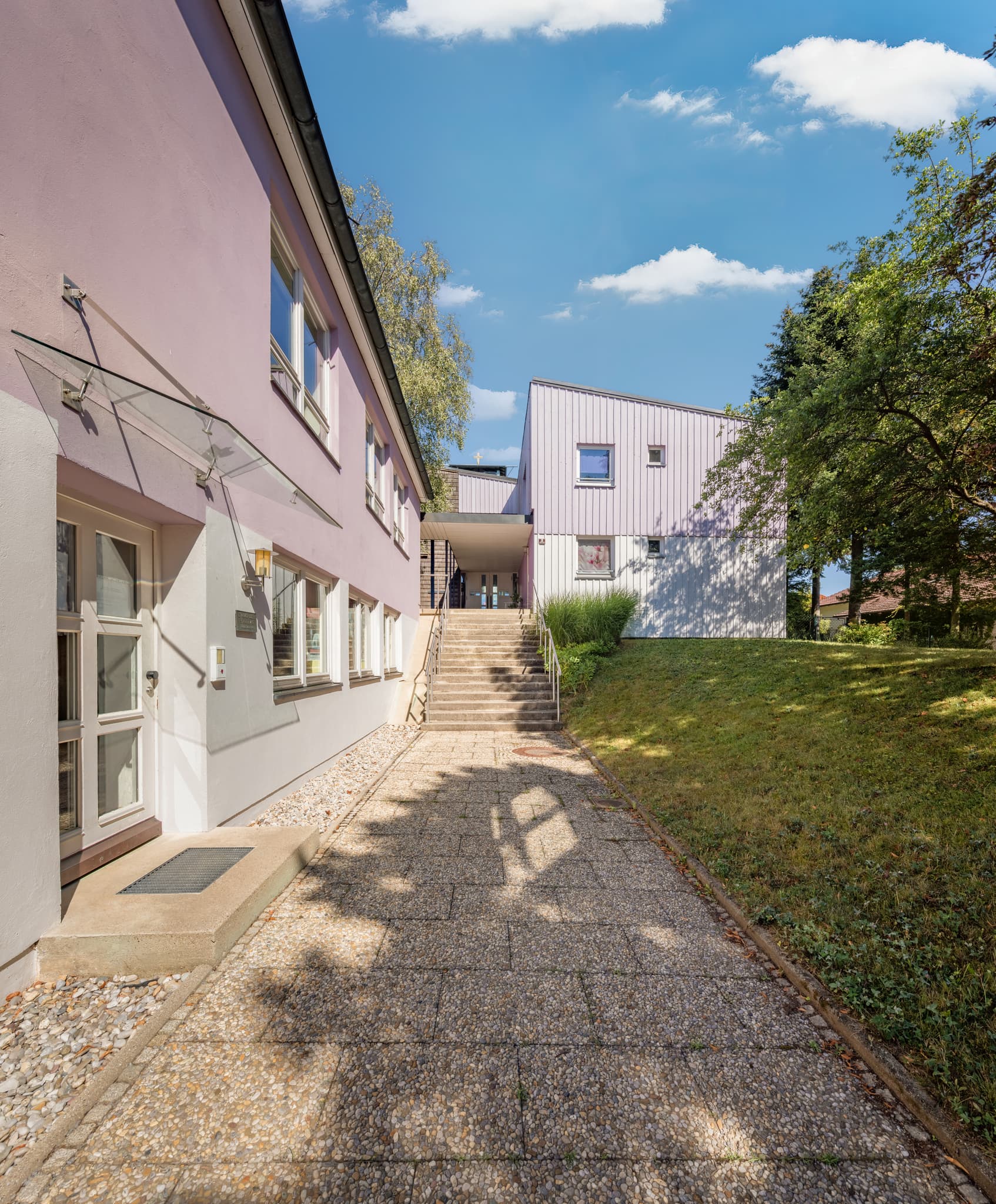 Die Evangelisch-Lutherische Kirchengemeinde St. Johannes in Bad Griesbach im Rottal, Landkreis Passau, Niederbayern, Deutschland, unter strahlend blauem Himmel.