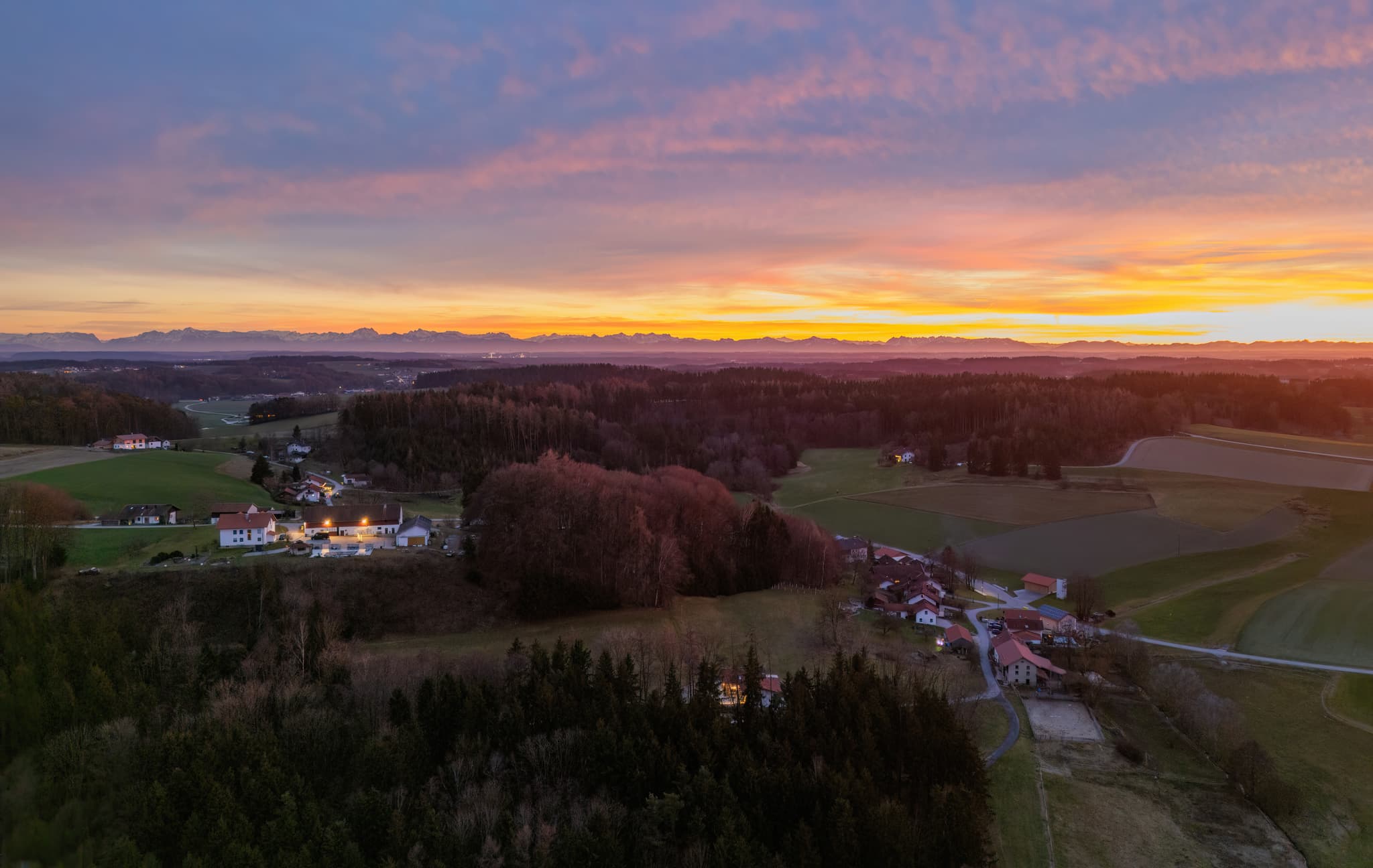 Ländliche Landschaft mit Siedlungen, Wäldern und Feldern bei Sonnenuntergang in Reischach, Landkreis Altötting, Oberbayern, Inn-Salzach, Deutschland.