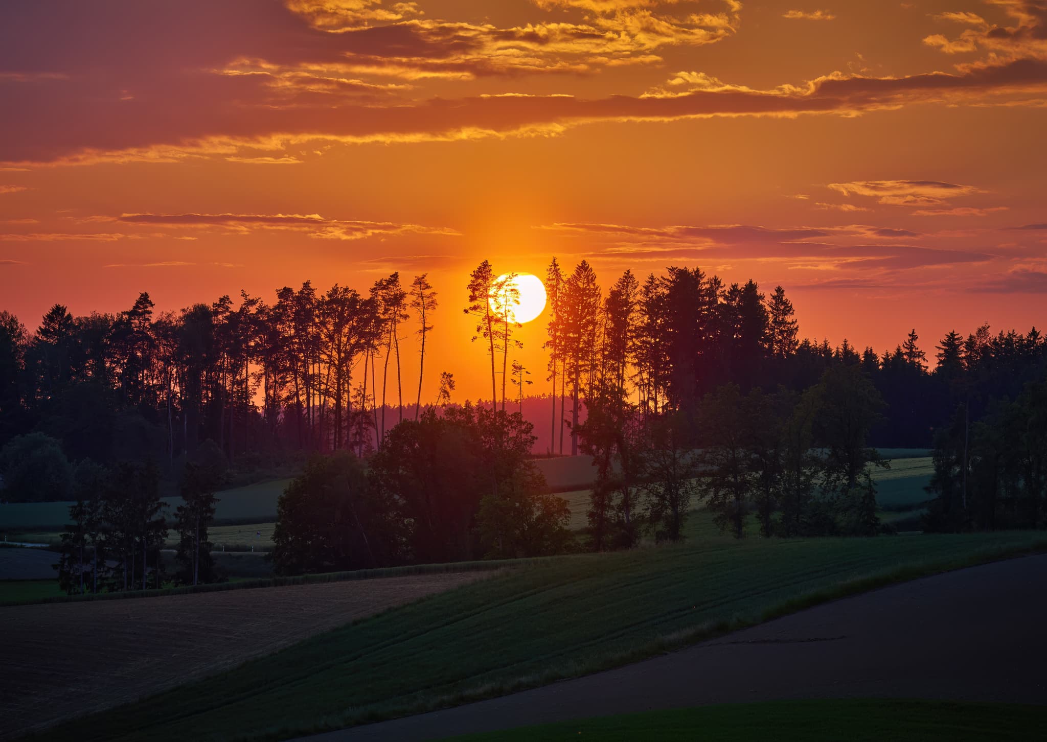 Atemberaubender Sonnenuntergang über den Feldern bei Holzham in Niederbayern, Deutschland. Region Rottal-Inn, Niederbayern. Wunderschöne Naturlandschaft.