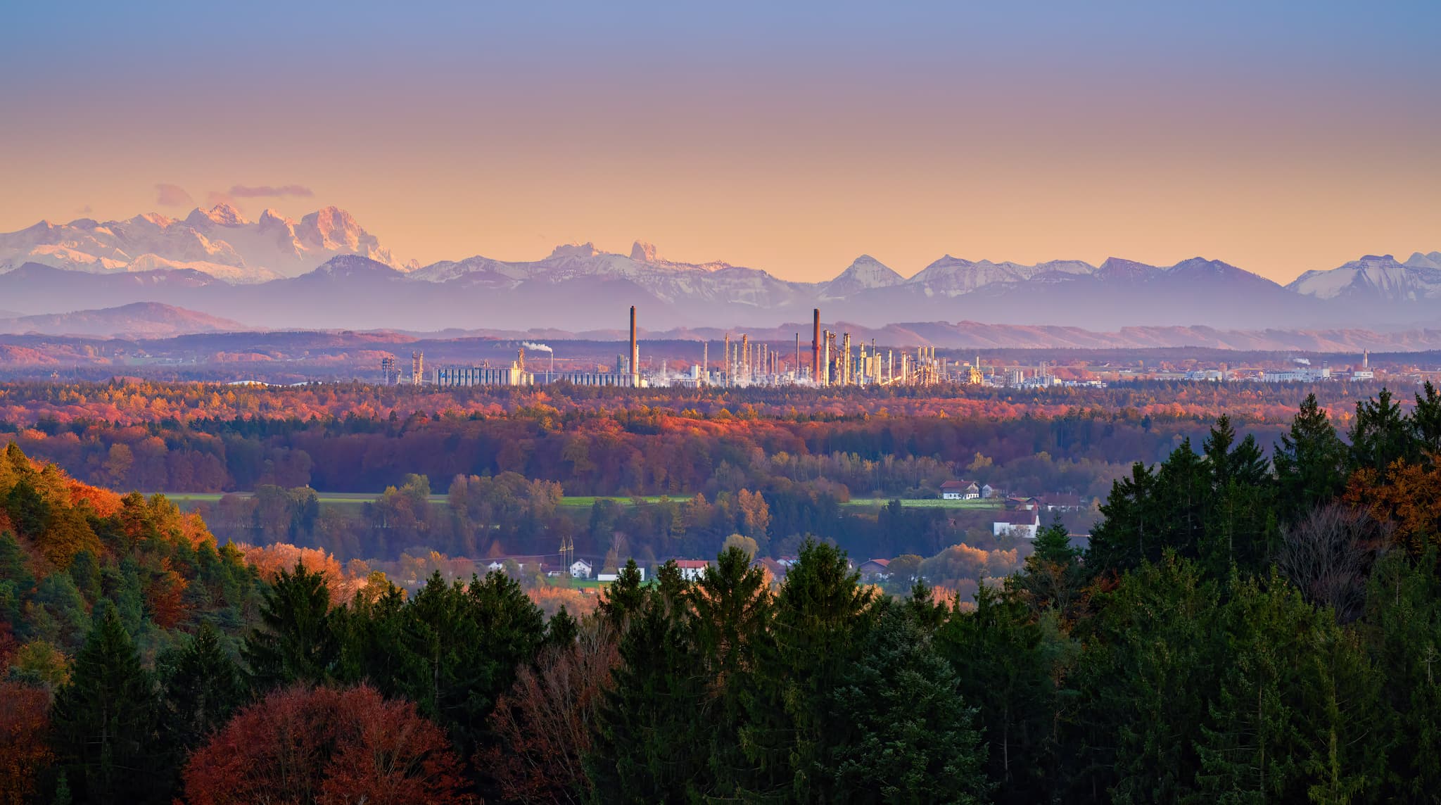 Panoramablick von Pfaffenberg in der Gemeinde Erlbach im Landkreis Altötting, Oberbayern, zeigt eine Industrielandschaft (Borealis, OMV, Wacker) und die Alpen.