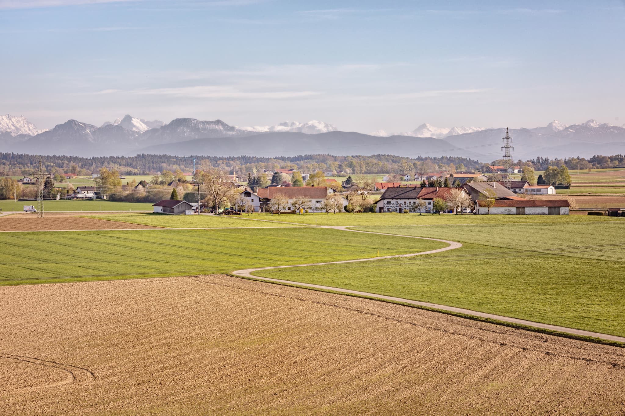 Blick von Eschlberg Aussicht bei Mehring, Altötting, Oberbayern. Weite Felder, Dorf und Alpenpanorama im Hintergrund. Ländliche Landschaft.