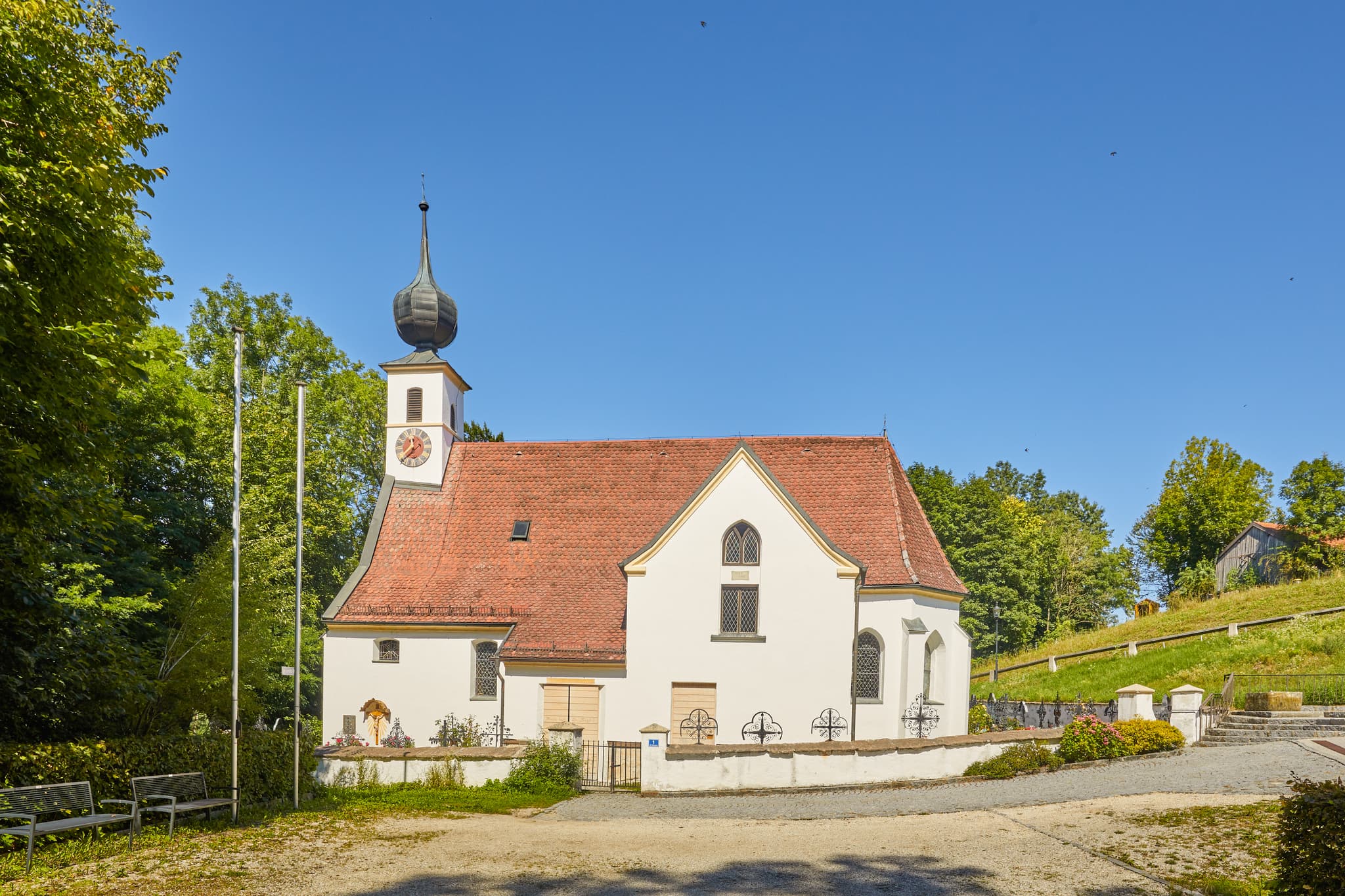 Pfarrkirche Radegundis in Hadermarkt, St. Radegund, Braunau am Inn, Oberösterreich, Innviertel, Österreich. Kirchengebäude in grüner Landschaft.
