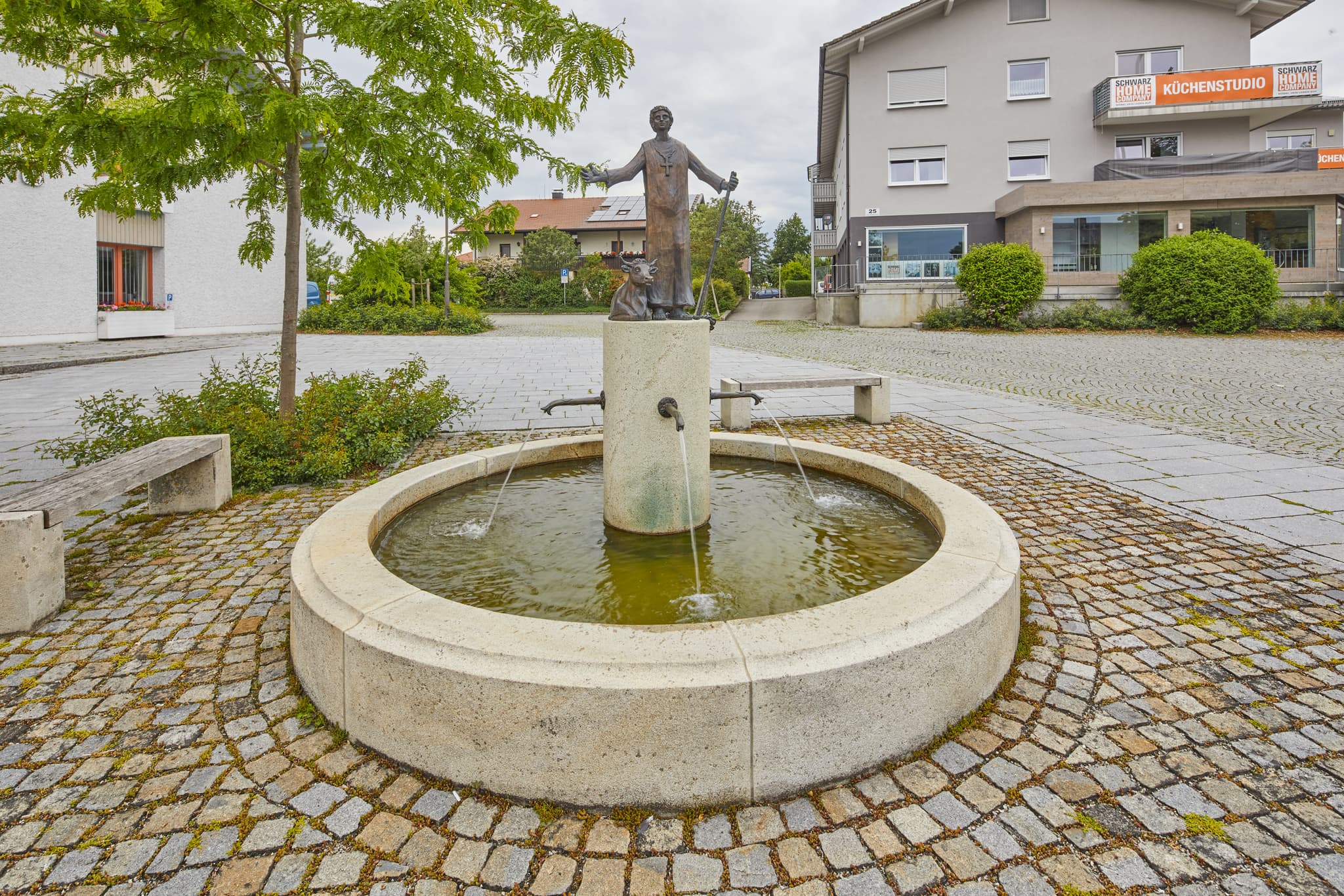 Der Dorfbrunnen in Kirchweidach, Oberbayern, liegt vor dem Rathaus. Er ist ein wunderschönes Beispiel für regionale Architektur in der Region Inn-Salzach