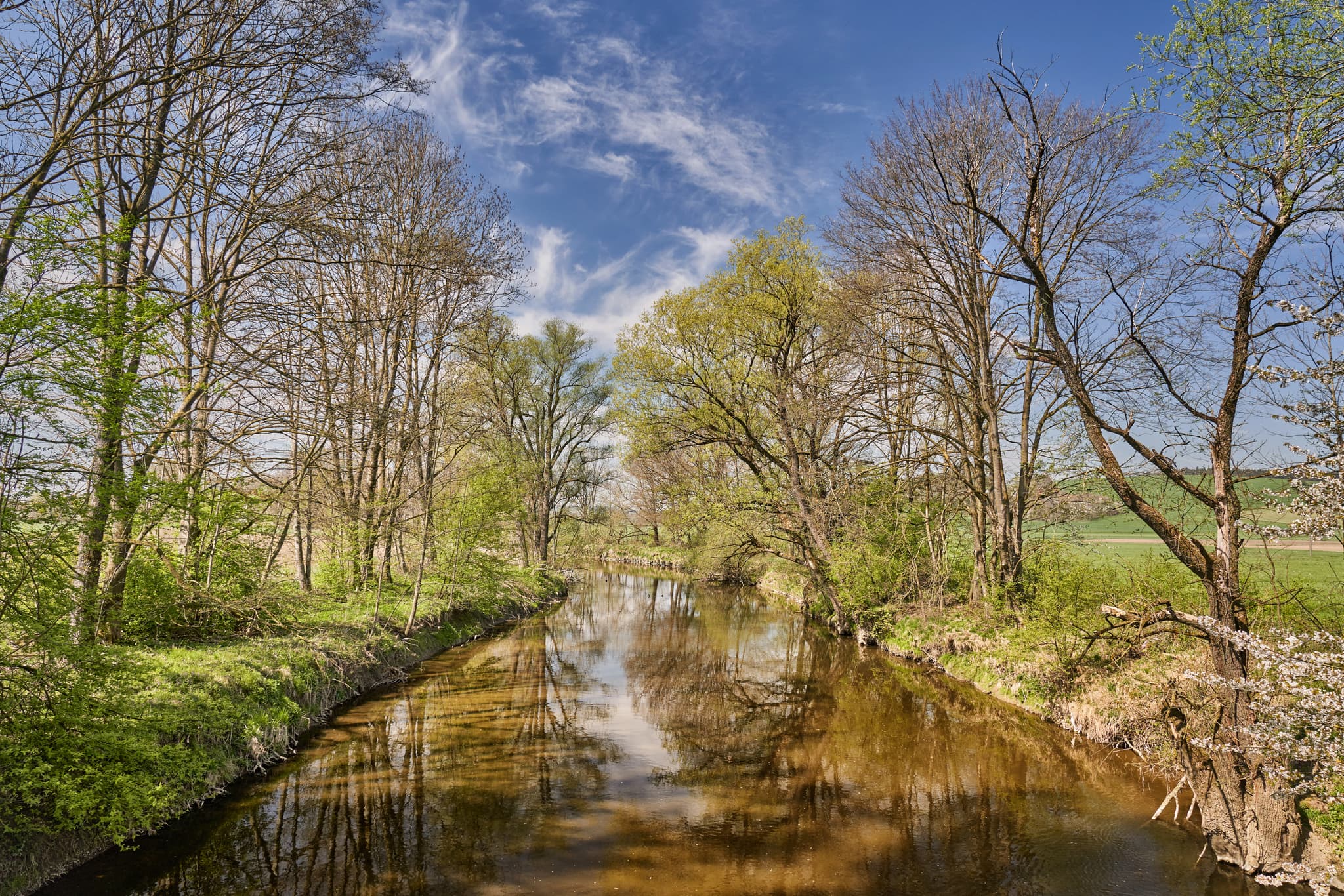 Idyllische Isen Flusslandschaft bei Mößling, Mühldorf am Inn, Oberbayern. Ruhiger Bachlauf mit Bäumen und grüner Ufervegetation.