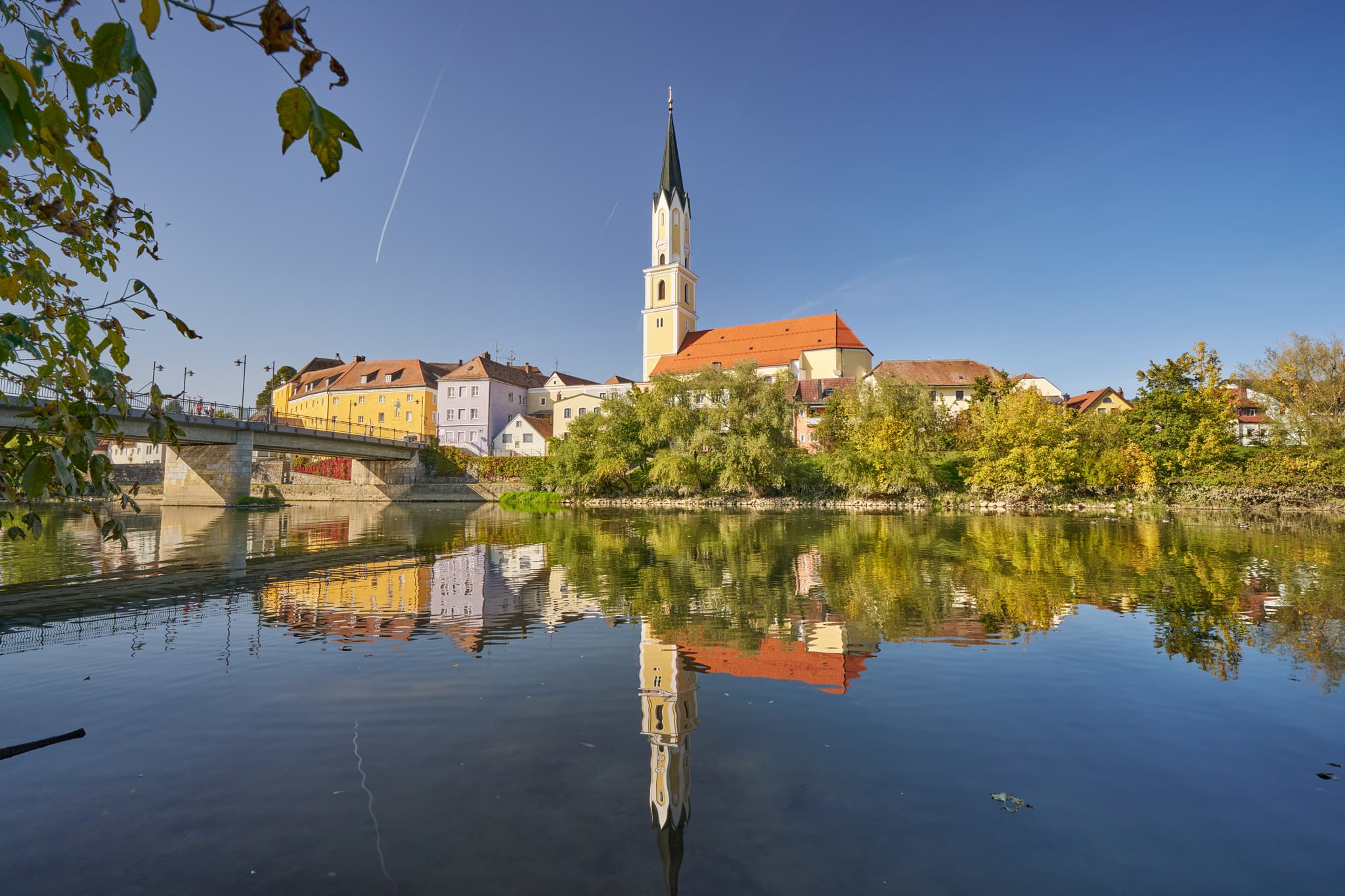 Stadtansicht von Vilshofen an der Vils im Landkreis Passau, Niederbayern. Stadt am Fluss mit Kirche, spiegelt sich im Wasser. Region Donau-Wald, Deutschland.