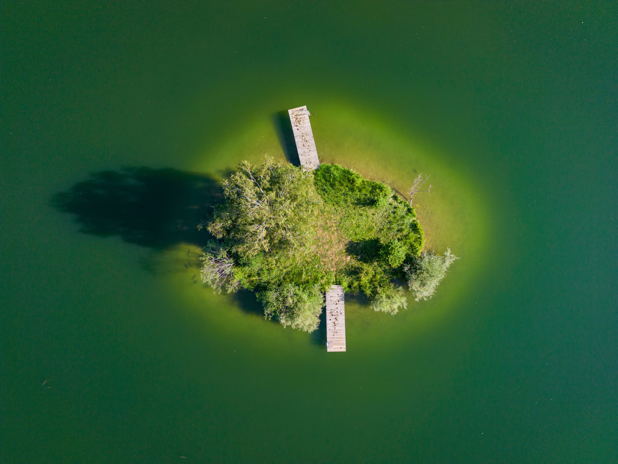 Atemberaubendes Luftbild vom Peracher Badesee bei Perach in Oberbayern, Inn-Salzach, Deutschland. Idyllische Insel mit Steg.
