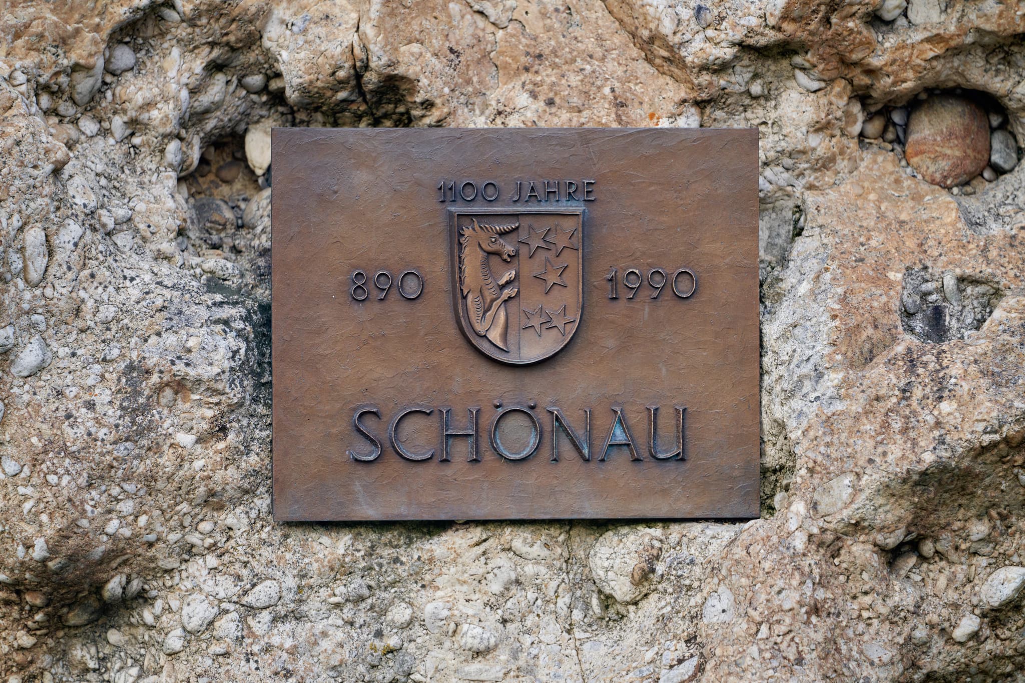 Gedenkplakette '1100 Jahre Schönau' (890-1990) auf Steinmauer. Motiv aus Gemeinde Stein Hörniweg, Schönau, Rottal-Inn, Niederbayern, Holzland, Deutschland.
