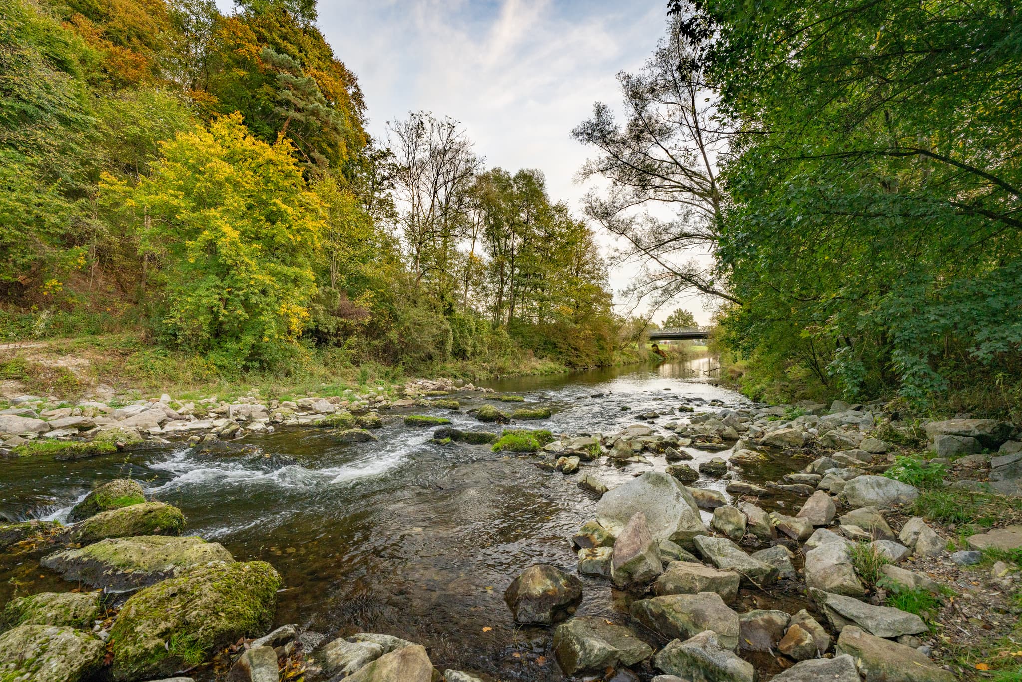 Fluss Isen bei Winhöring im Landkreis Altötting, Oberbayern, Deutschland, zeigt einen naturnahen Flusslauf mit Steinen und Ufervegetation, Region Inn-Salzach.